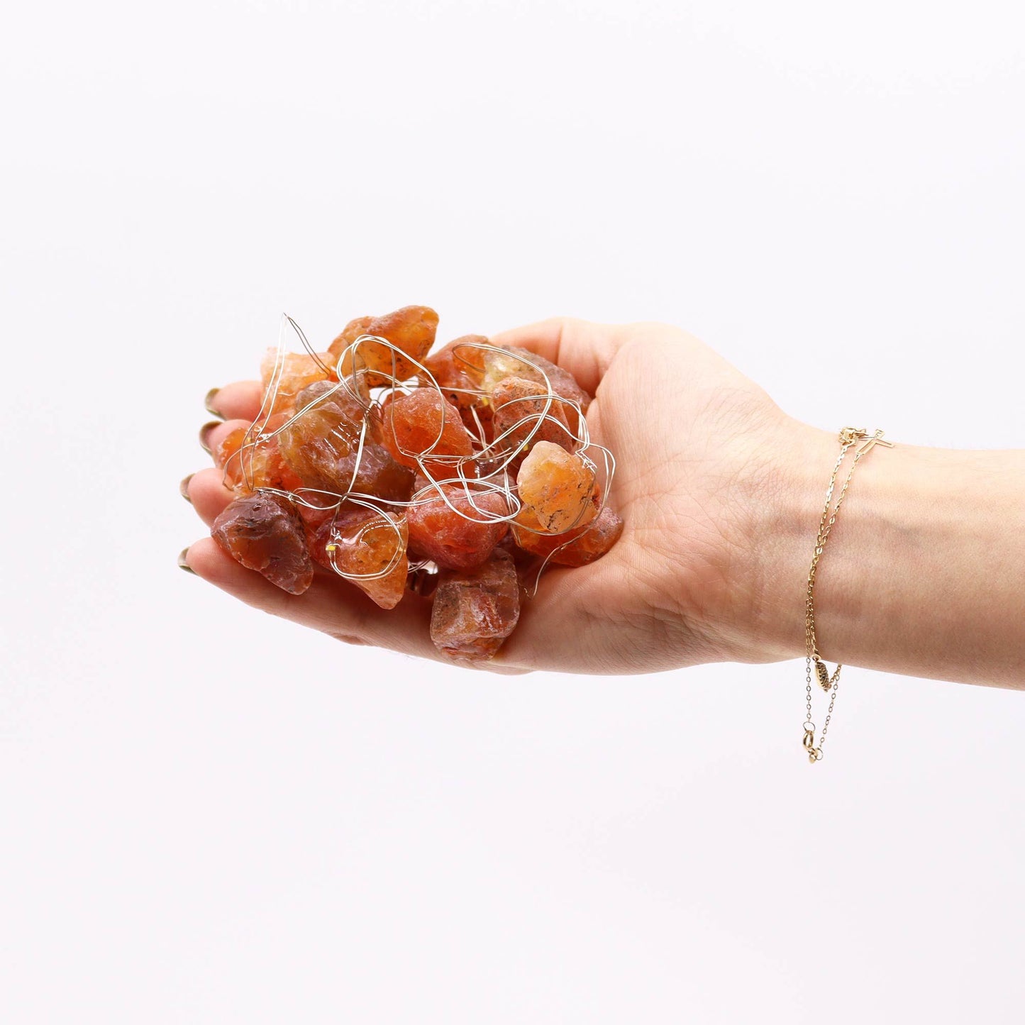 Hand holding a cluster of Orange Jade Gemstone Enchantment Lights, showcasing the beautiful orange jade gems that create a stunning atmosphere. An excellent choice for Christmas Gift Home Fragrance.