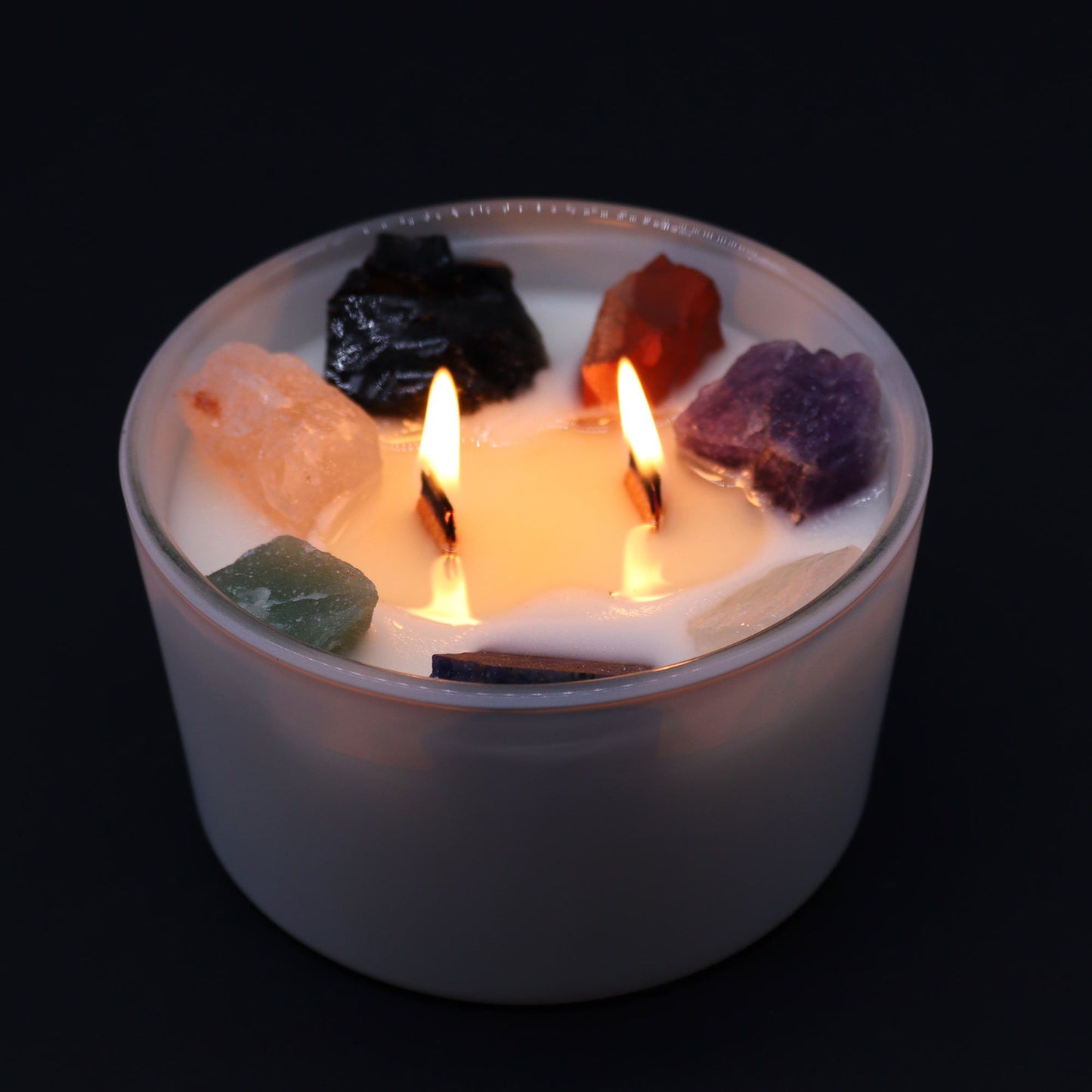 Large Chakra Gemstone Candle - Moon Beams Scent & Light burning with two wicks, surrounded by vibrant crystals, creating a warm atmosphere for Christmas home fragrance.