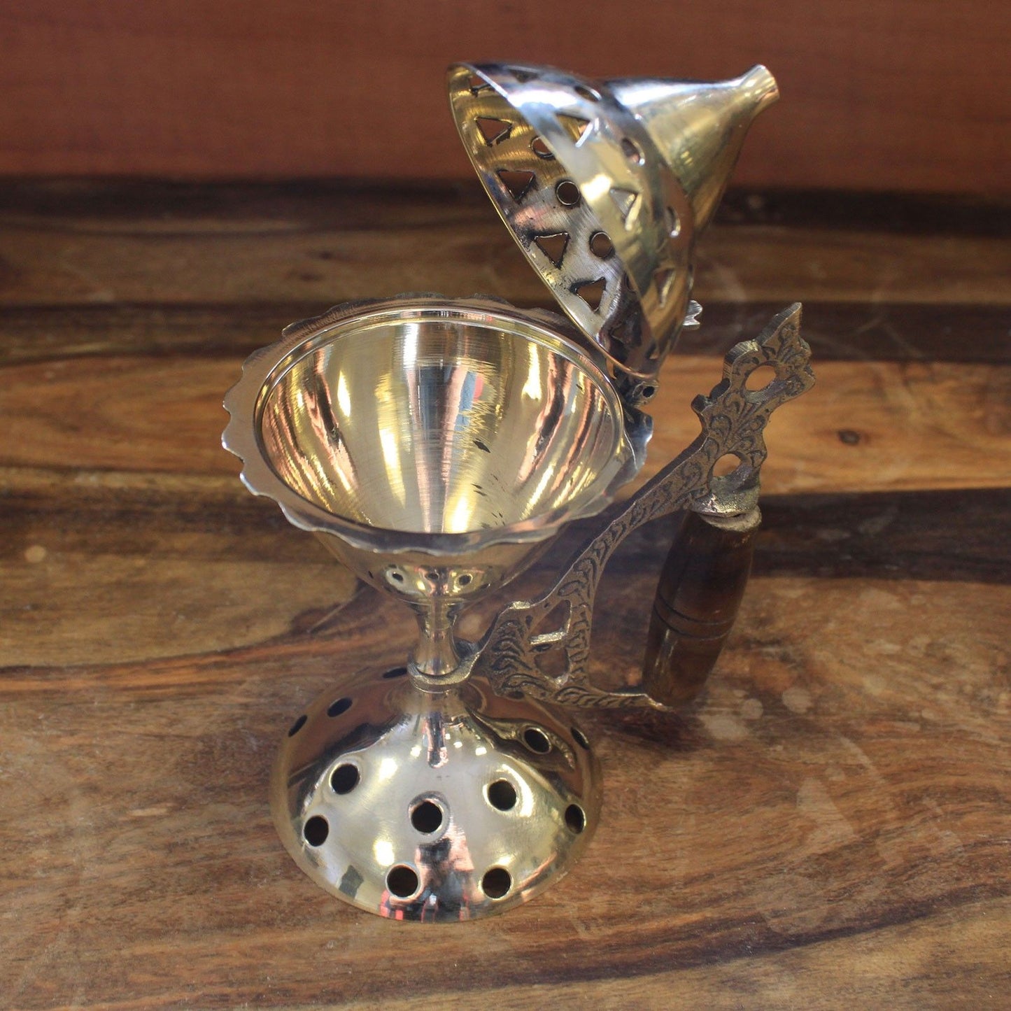 View from above of an Elegant Brass Cone Incense Burner With Wooden Handle, featuring the vented lid design. Great for enhancing your space with delightful aromas while being a thoughtful {{scent}} {{product_type}} – Christmas Gift Home Fragrance.