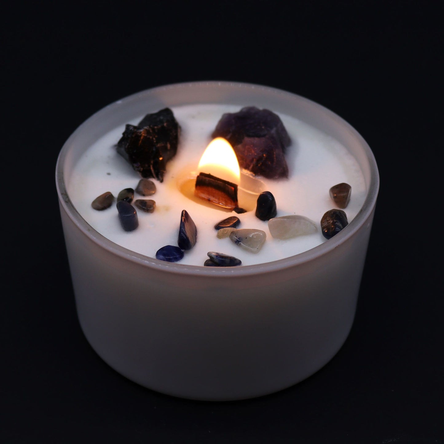 The Solar Plexus Chakra Candle lit, showcasing its glowing gemstones, particularly Amethyst and Black Agate. This candle diffuses the enchanting fragrance of "Deep in the Forest" and is an excellent choice for a Christmas gift to enhance home ambience.