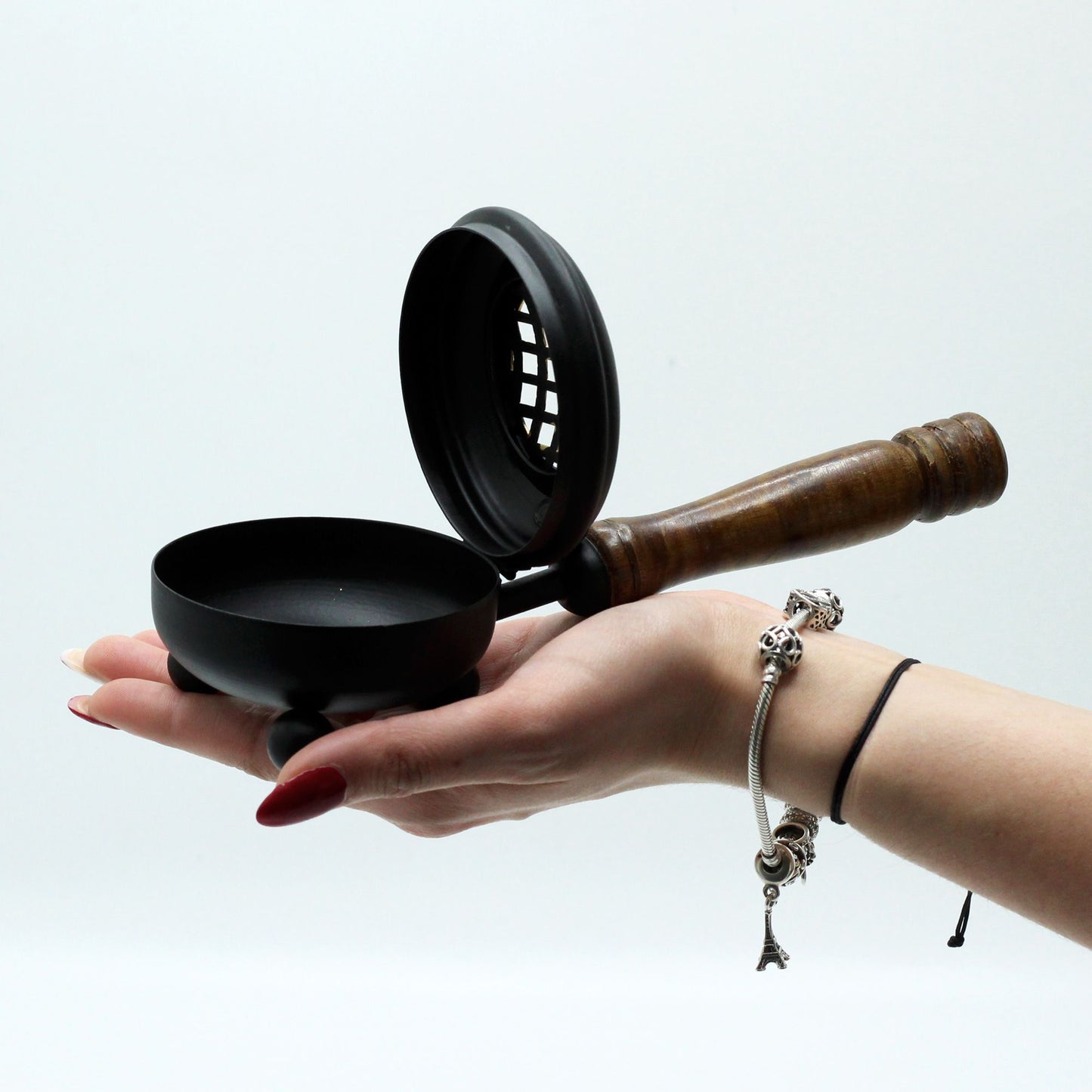Rustic Cast Iron Incense Burner With Wooden Handle – Gold Accents, held gently in a hand to demonstrate its size and design. An ideal choice for enhancing home fragrance, making it a thoughtful Christmas Gift Home Fragrance.