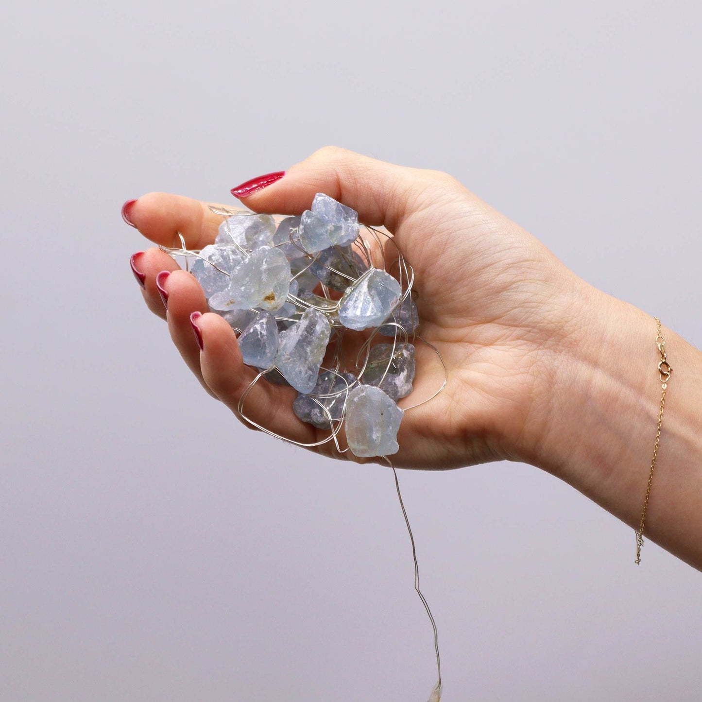 Hand holding a cluster of Celestite Gemstone Enchantment LED Lights, illustrating their delicate design, ideal for creating a magical ambiance at home. {{scent}} {{product_type}} – Christmas Gift Home Fragrance.