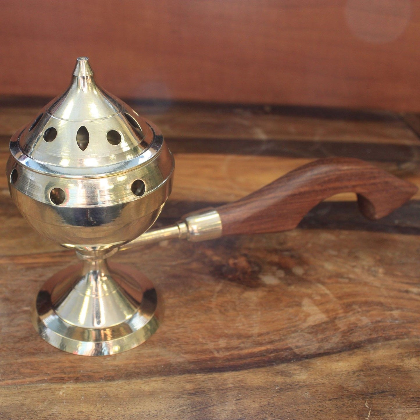 A single elegant brass incense burner featuring a beautifully crafted wooden handle, ready for use in meditation or rituals. This Brass Incense Burner makes a thoughtful Christmas gift for those who appreciate home fragrance.