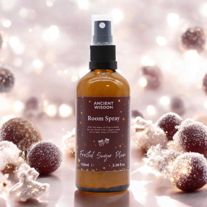 Frosted Sugar Plum Room Spray 100ml displayed against a wintery background, perfect for a Christmas gift or stocking filler. This festive fragrance captures the delightful scents of sugared plums, making it an ideal home fragrance. Treat yourself or someone special to this pamper pack, perfect for aromatherapy during the winter season, evoking the essence of winter spice, cinnamon orange, frankincense myrrh, and a white Christmas.