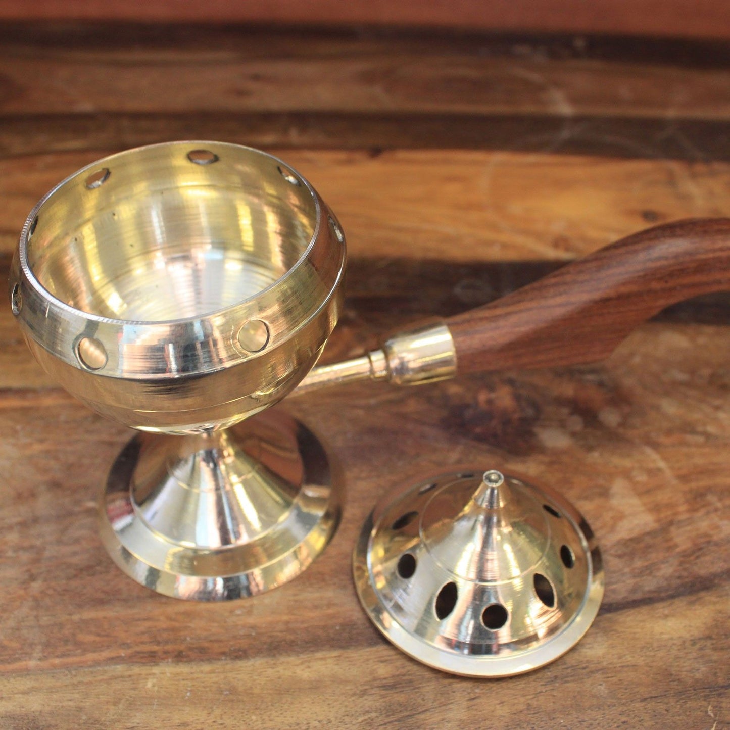 An elegant brass incense burner with a wooden handle shown with its lid removed, highlighting its intricate design and functionality. Perfect for home altar and meditation, this Brass Incense Burner is an ideal Christmas gift for home fragrance lovers.