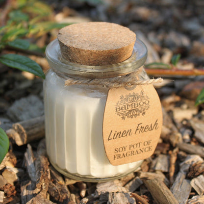Linen Fresh Eco-Friendly Soy Wax Candle Pot set on natural wood, highlighting its charming rustic look. An excellent choice for Christmas gift home fragrance.