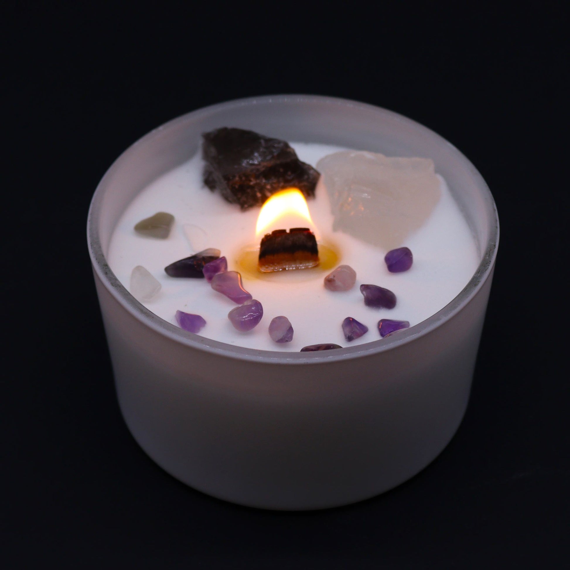 Crown Chakra Candle – Ocean Breeze Scent lit, surrounded by beautiful gemstones, creating a warm glow. Perfect for a calming Christmas Gift Home Fragrance.