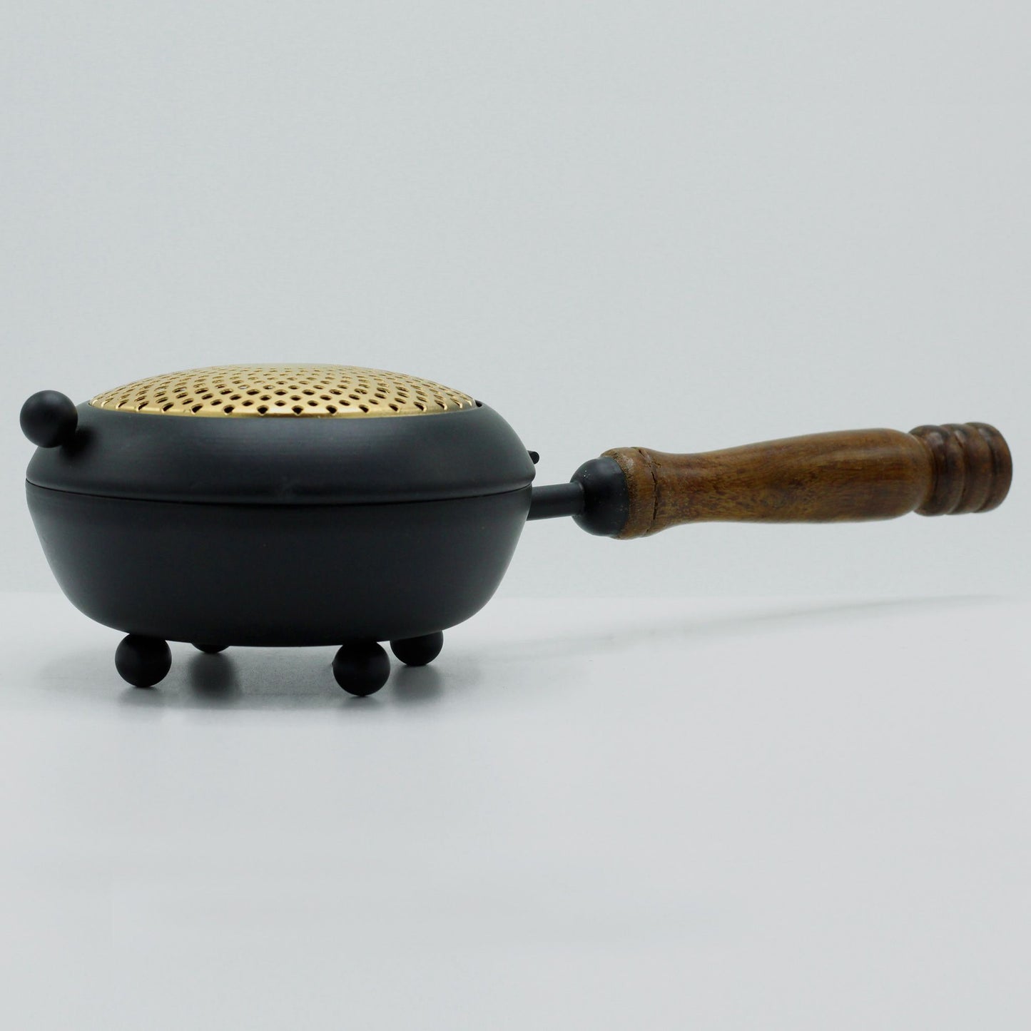 Side view of the Elegant Large Iron Incense Burner With Gold Accents, highlighting its elegant curves and wooden handle. A beautiful addition to home decor, this {{scent}} {{product_type}} – Christmas Gift Home Fragrance enhances any ritual.