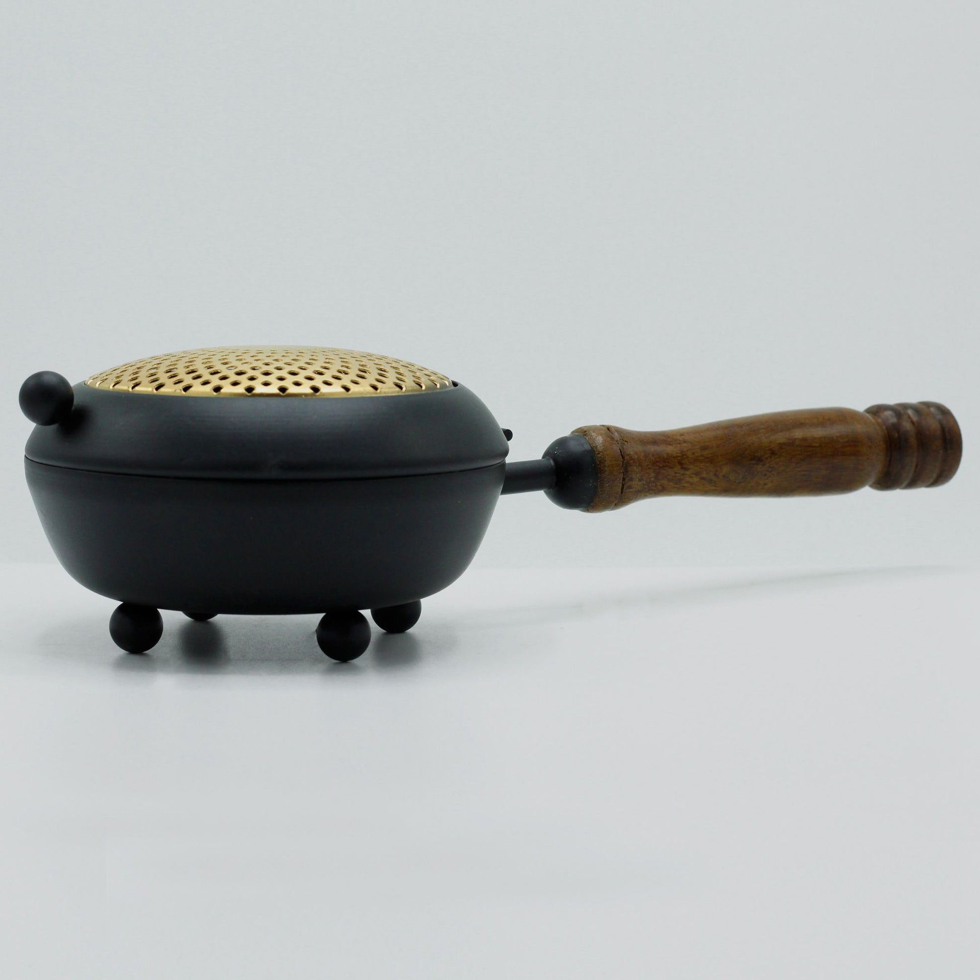 Side view of the Elegant Large Iron Incense Burner With Gold Accents, highlighting its elegant curves and wooden handle. A beautiful addition to home decor, this {{scent}} {{product_type}} – Christmas Gift Home Fragrance enhances any ritual.