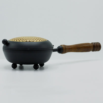 Side view of the Elegant Large Iron Incense Burner With Gold Accents, highlighting its elegant curves and wooden handle. A beautiful addition to home decor, this {{scent}} {{product_type}} – Christmas Gift Home Fragrance enhances any ritual.