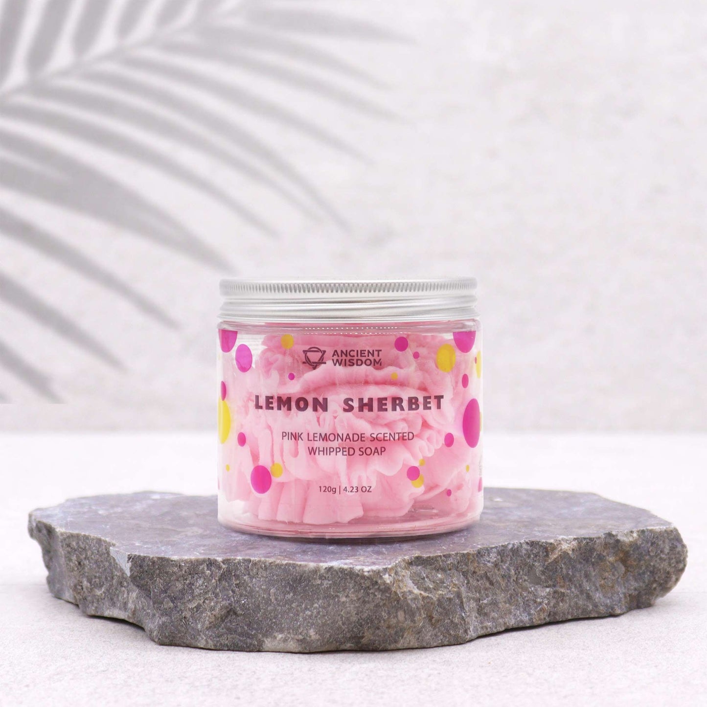 Stylish presentation of Pink Lemonade Whipped Soap 120G jar against a stone backdrop. This whipped soap is a vegan, moisturising treat with a refreshing scent, ideal for holiday gifting as a Christmas gift home fragrance.