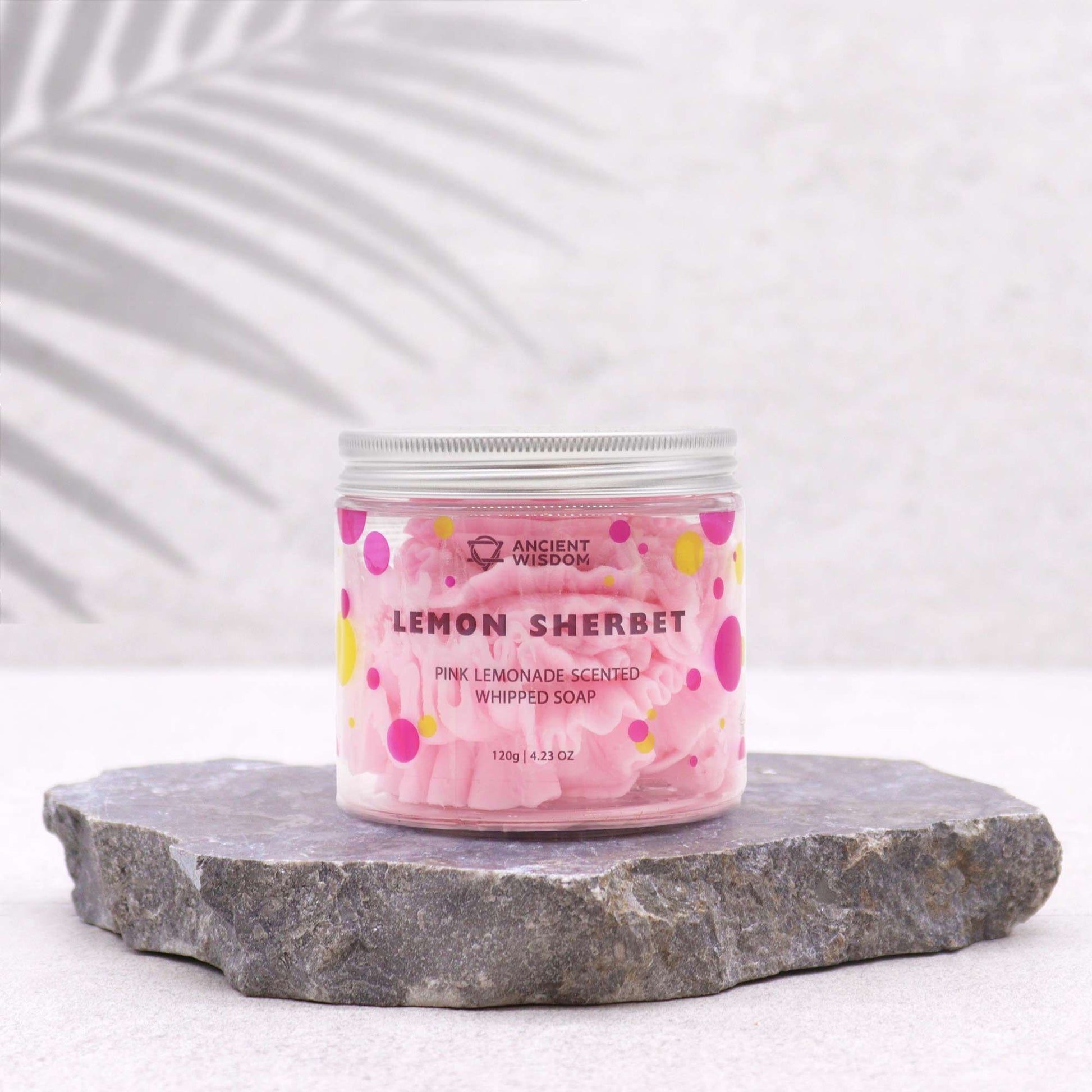 Stylish presentation of Pink Lemonade Whipped Soap 120G jar against a stone backdrop. This whipped soap is a vegan, moisturising treat with a refreshing scent, ideal for holiday gifting as a Christmas gift home fragrance.