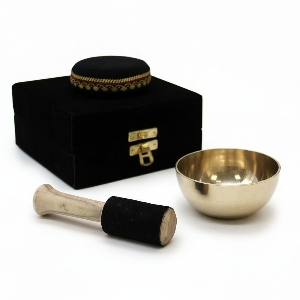 Brass Singing Bowl Set - 9cm Tibetan Gift for Inner Calm displayed with the bowl and stick alongside the luxurious black box, perfect for a unique home decor piece. This {{scent}} {{product_type}} – Christmas Gift Home Fragrance promotes mindfulness.