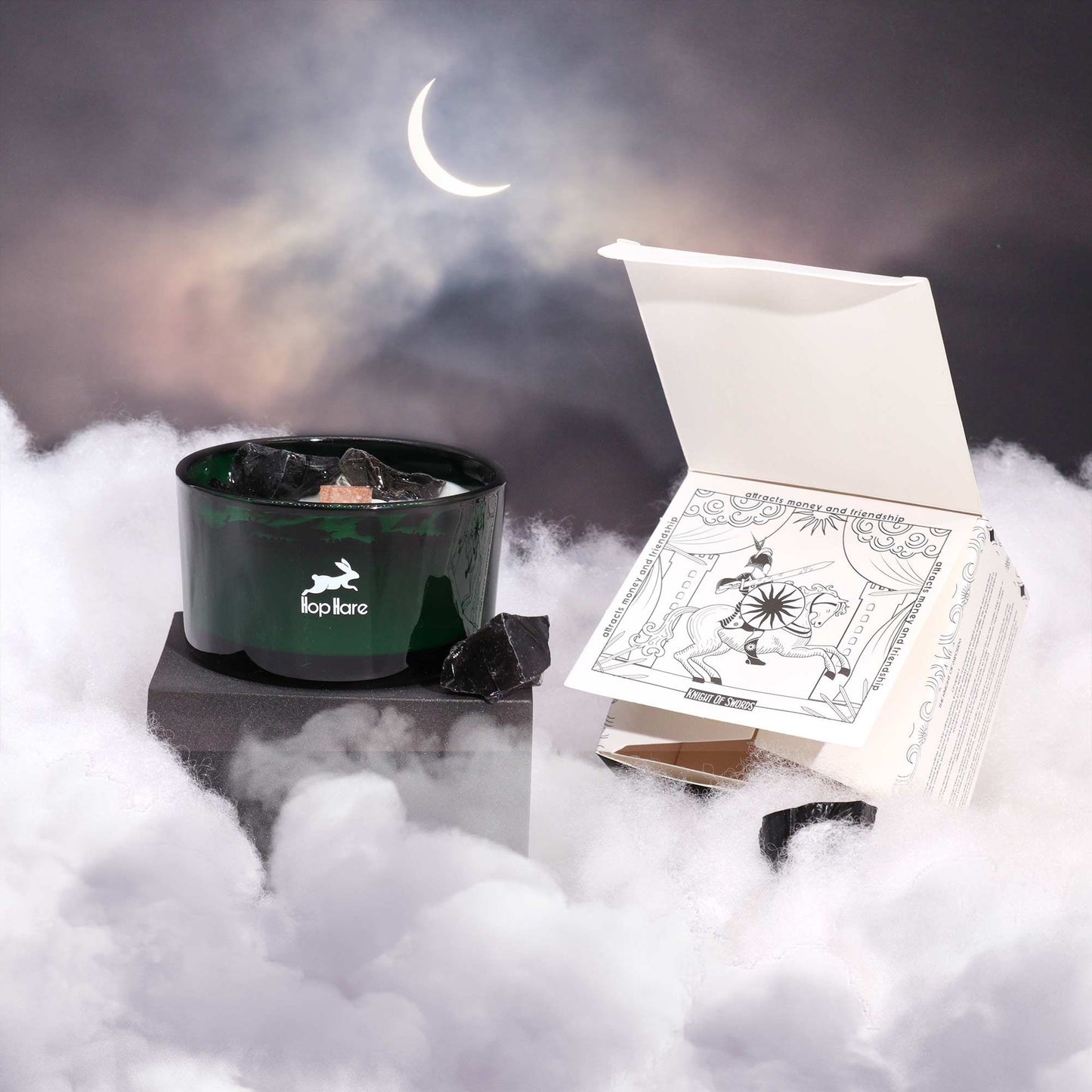 Hare Crystal Flower Candle - Knight of Swords displayed amidst ethereal clouds and a crescent moon, showcasing its elegant design and Black Obsidian accents. A perfect addition for cosy vibes, it serves as a wonderful Christmas Gift Home Fragrance.