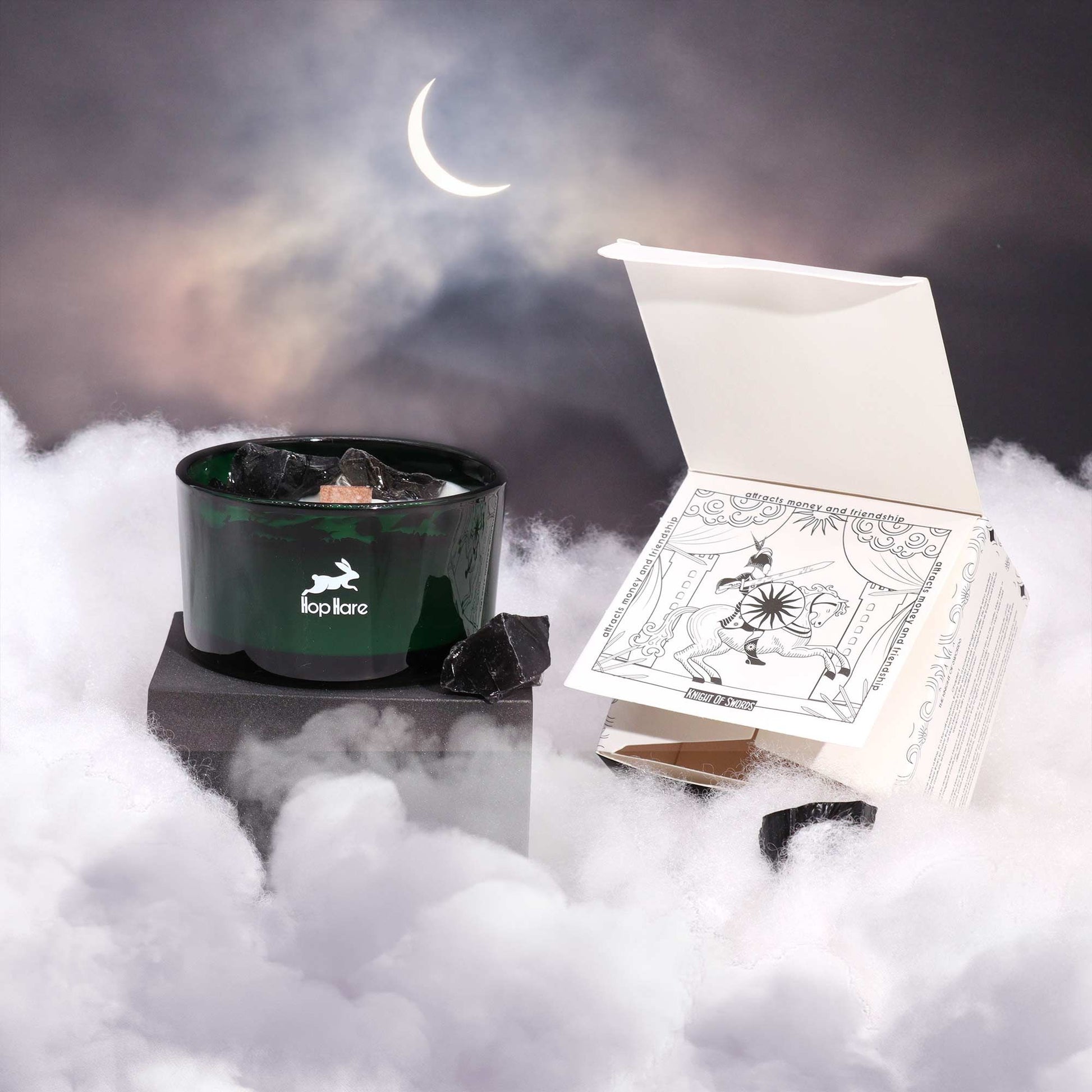 Hare Crystal Flower Candle - Knight of Swords displayed amidst ethereal clouds and a crescent moon, showcasing its elegant design and Black Obsidian accents. A perfect addition for cosy vibes, it serves as a wonderful Christmas Gift Home Fragrance.