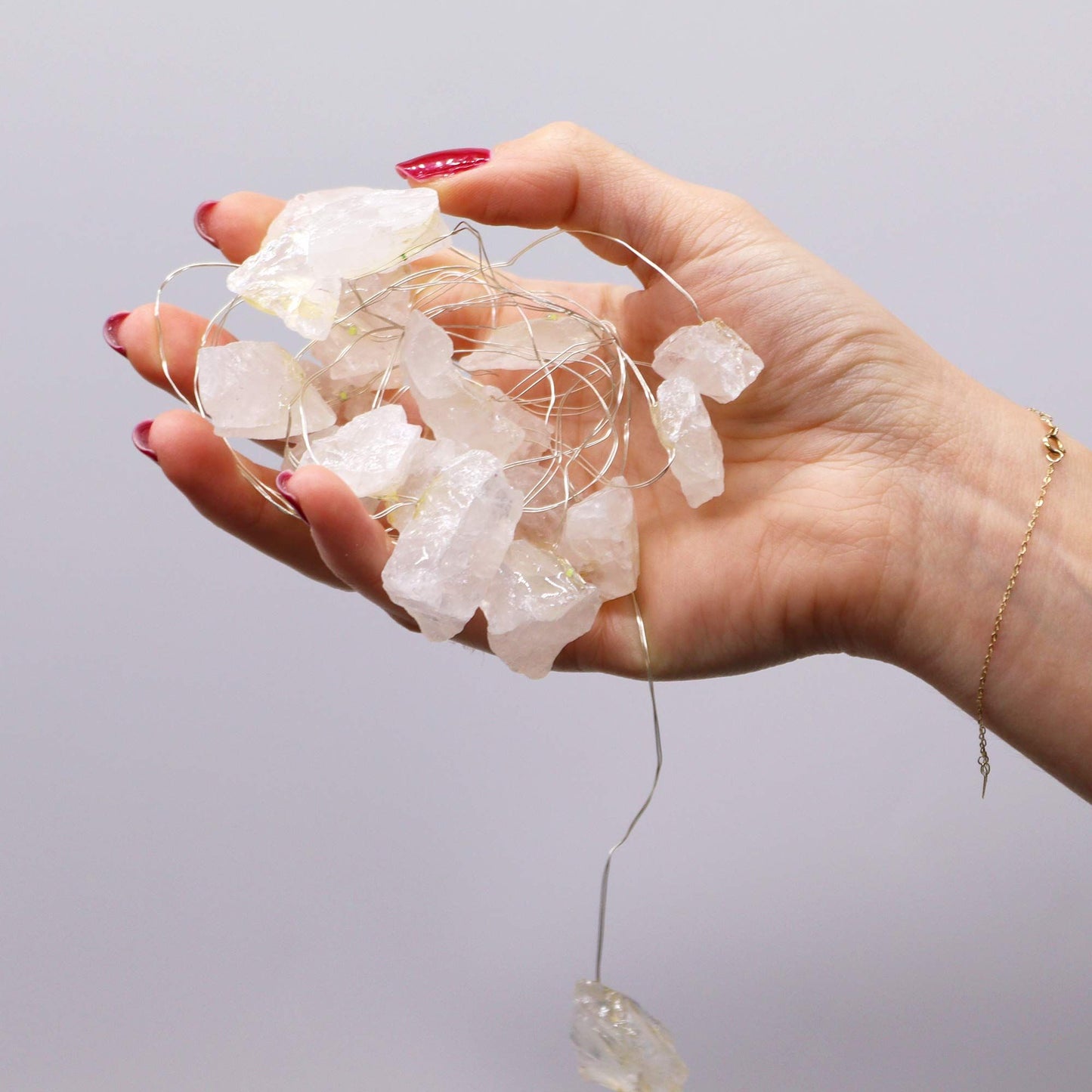 Hand holding Rock Quartz Gemstone Enchantment LED String Lights, displaying the enchanting crystal rocks for cosy homely vibes, a great Christmas gift idea.