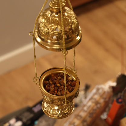 Close-up of the Handcrafted Hanging Brass Incense Burner filled with aromatic resin. This beautiful piece embodies traditional elegance, making it an ideal Christmas gift for home fragrance enthusiasts.