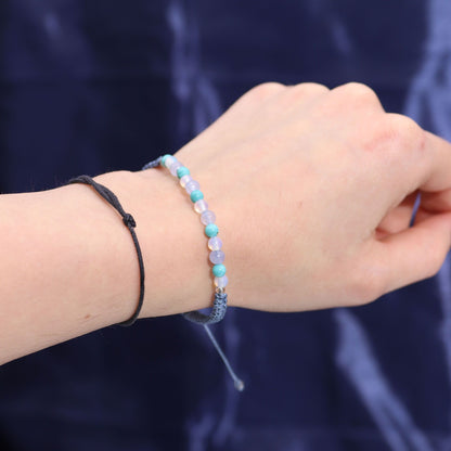 Zodiac Crystal Candle with Gemstone Bracelet - Pisces featuring a close-up of a hand adorned with a beautiful gemstone bracelet alongside a minimalistic black string bracelet. Perfect for enhancing your inner harmony, this set is an ideal Christmas Gift Home Fragrance.