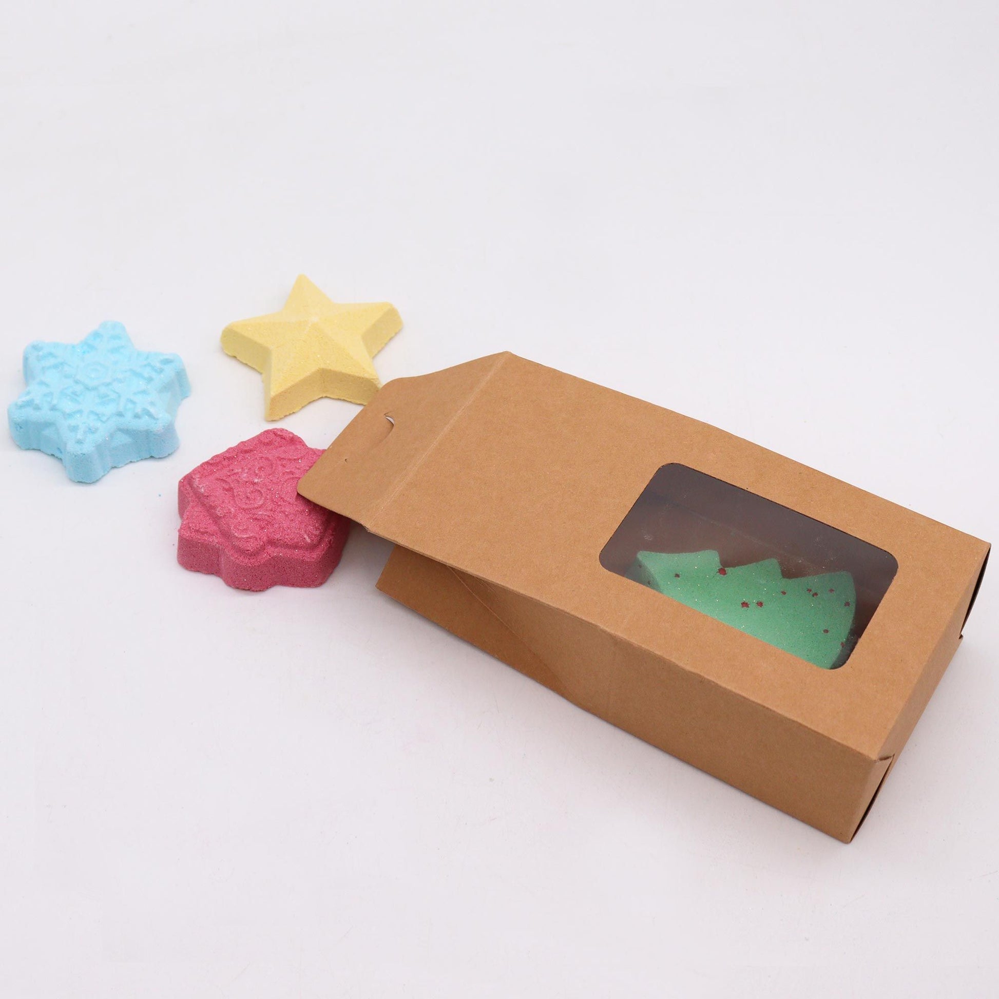 Christmas Wish List Christmas Bath Bomb Gift Pack featuring colourful shaped bath bombs including a green Christmas tree, pink gingerbread house, blue snowflake, and yellow star. Perfect for festive home fragrance and a delightful Christmas gift.