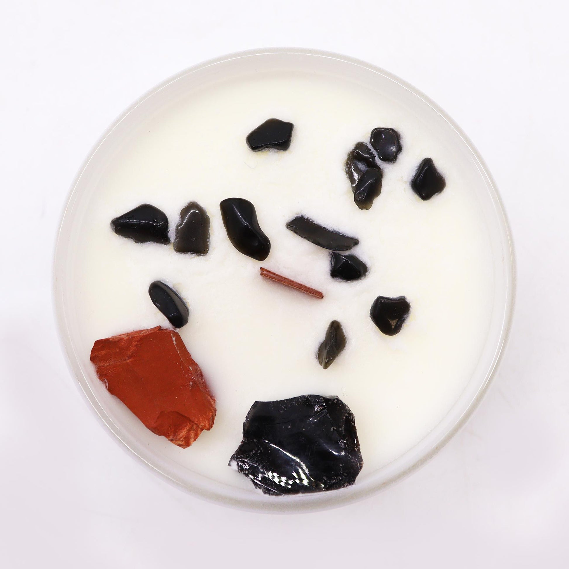 Top view of the Root Chakra Crystal Candle - Black Oud Scent with Gemstones, showcasing its unique gemstones including Red Jasper. A wonderful addition to any home, making it an ideal Christmas Gift Home Fragrance.