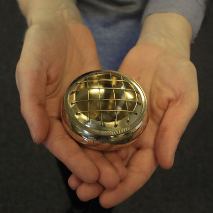 A person holding an Elegant Brass Charcoal Incense Jar, highlighting its portable design and beautiful craftsmanship. This stylish {{scent}} {{product_type}} makes a thoughtful Christmas Gift for enhancing home fragrance.