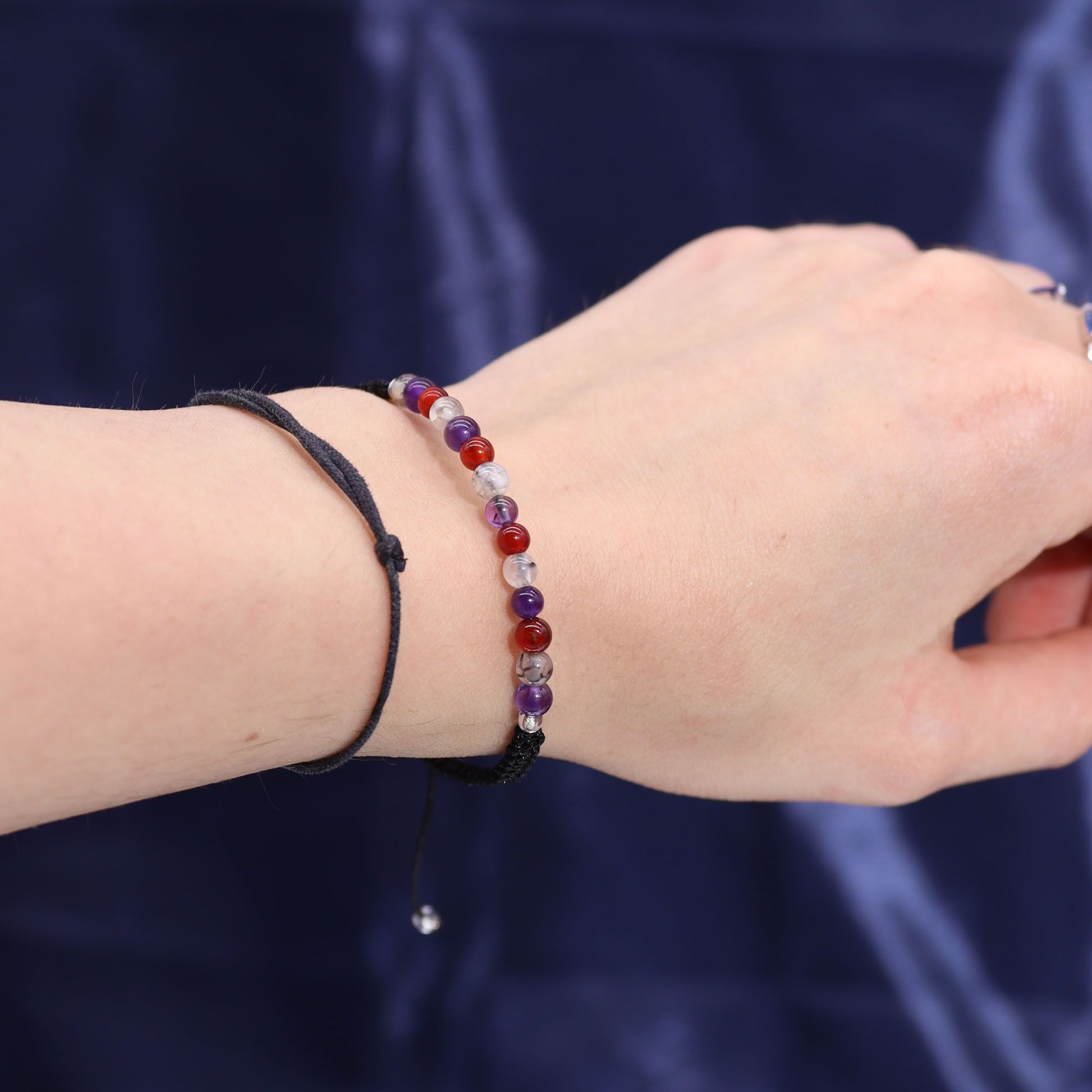 Close-up of a wrist wearing a beautiful gemstone bracelet featuring amethyst, carnelian, and moss agate from the Zodiac Crystal Candle with Gemstone Bracelet - Virgo. Enhance your self-care with this soothing piece, perfect as a Christmas Gift Home Fragrance.
