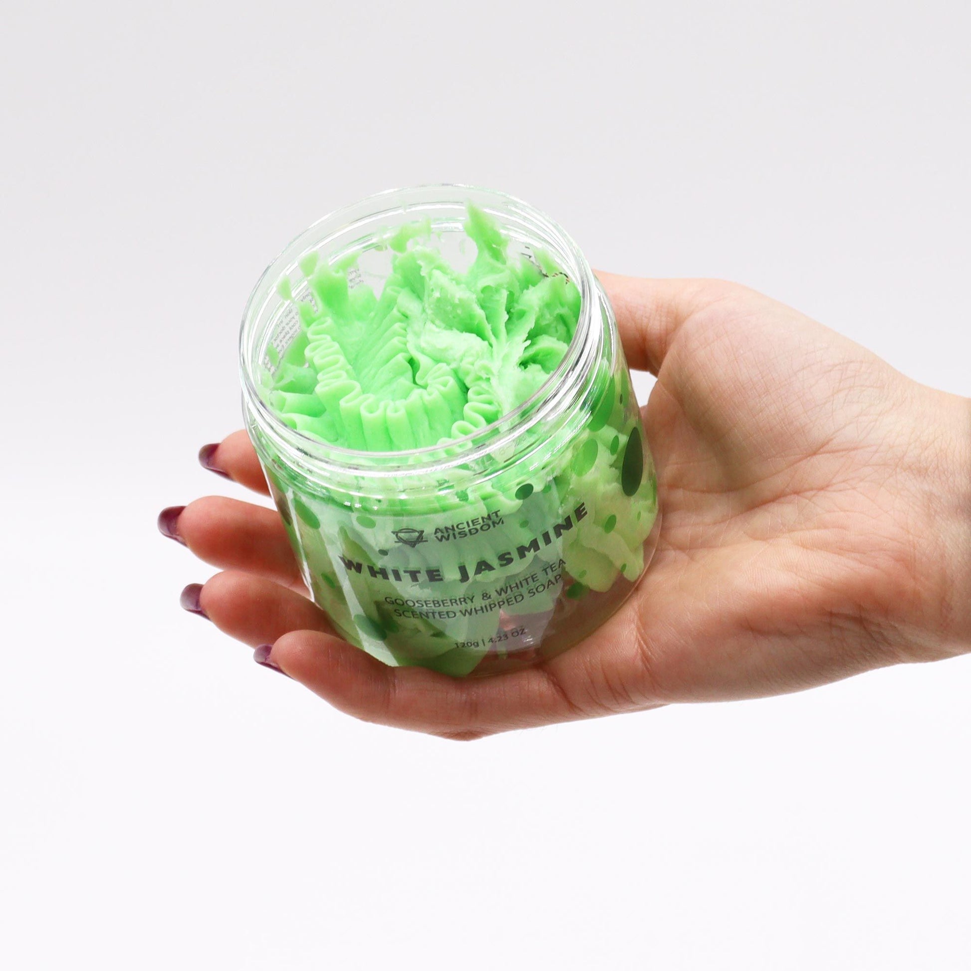 A hand holding the Gooseberry & White Tea Whipped Soap 120g – Vegan Luxury Care, showcasing its creamy texture. A lovely {{scent}} {{product_type}} – Christmas Gift Home Fragrance for skincare enthusiasts.