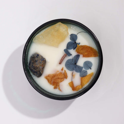 Top view of the Hop Hare Crystal Magic Flower Candle displaying its blend of Citrine and Sodalite, surrounded by dried flowers, embodying a warm and inviting home fragrance for Christmas gifts.
