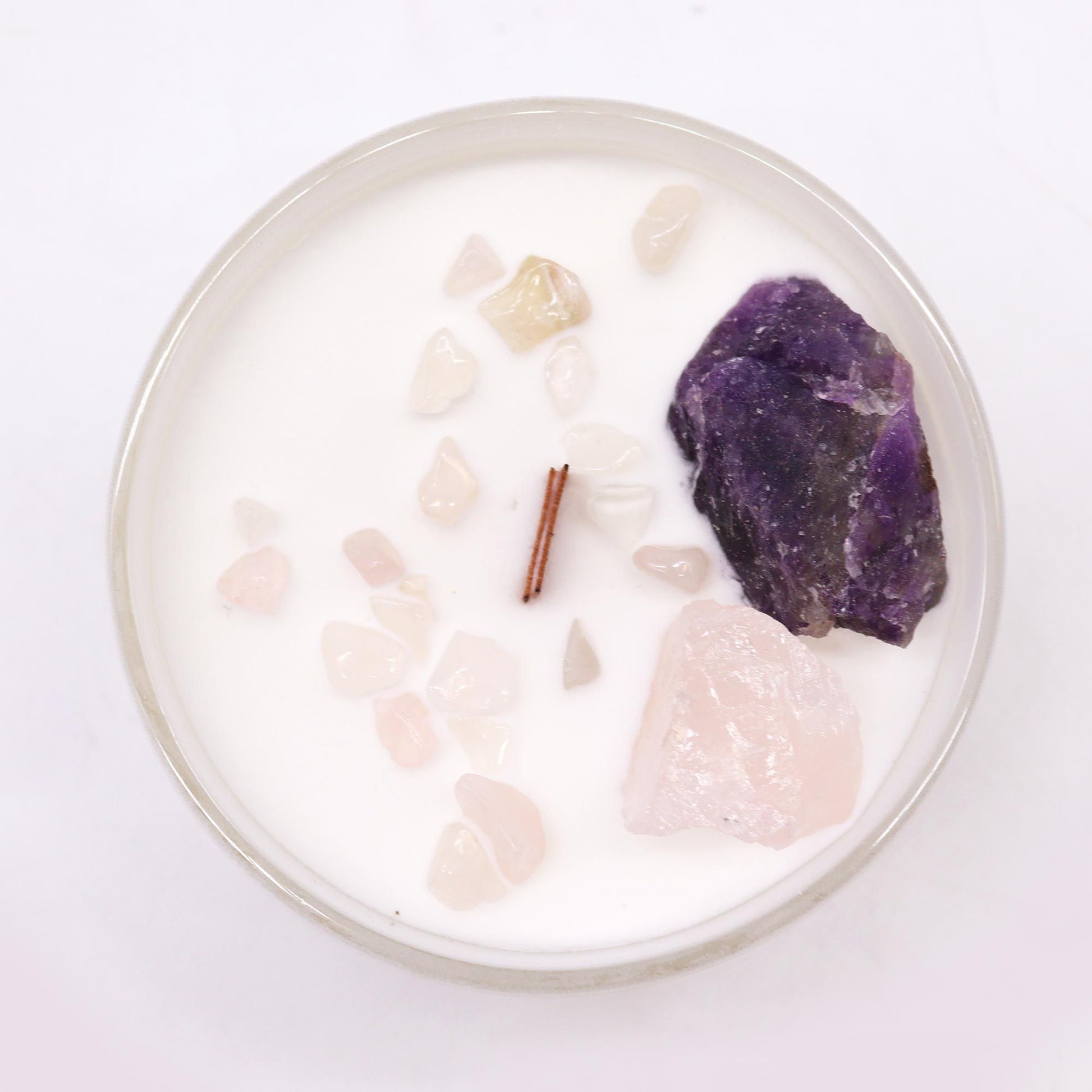 Bird's-eye view of the Third Eye Chakra Candle – Enhance Intuition & Inner Wisdom showcasing Amethyst and Rose Quartz gemstones surrounded by white wax. An ideal home fragrance for your Christmas celebrations.