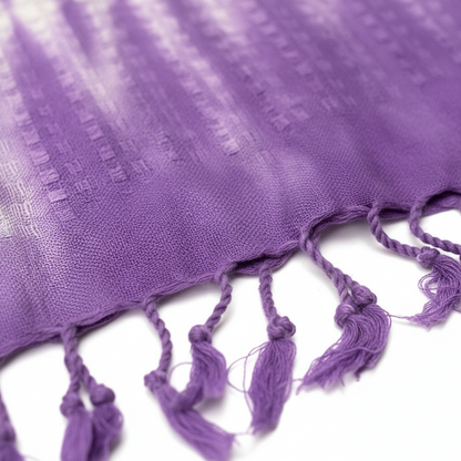 Close-up of a purple fabric with tassels on a white background