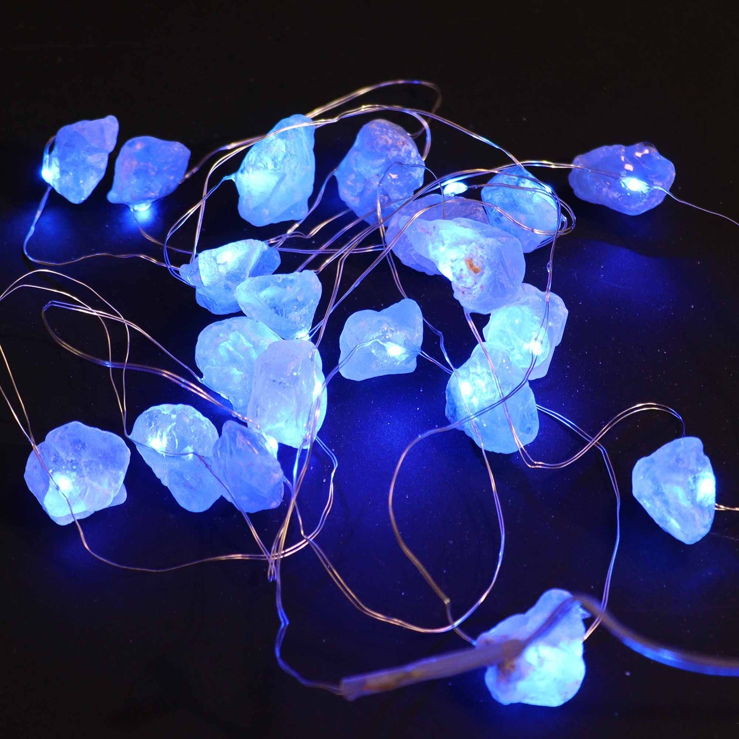 A vibrant display of Celestite Gemstone Enchantment LED Lights glowing a calming blue, perfect for adding charm to your home decor. {{scent}} {{product_type}} – Christmas Gift Home Fragrance.