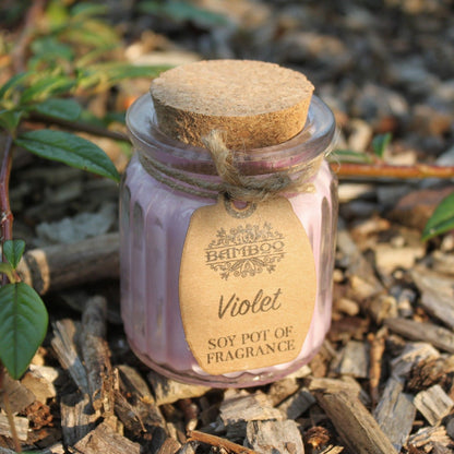 Violet Soy Wax Candle Pot resting on earthy ground, highlighting its natural appeal and eco-friendly features. This candle is a perfect choice for a Christmas Gift Home Fragrance.