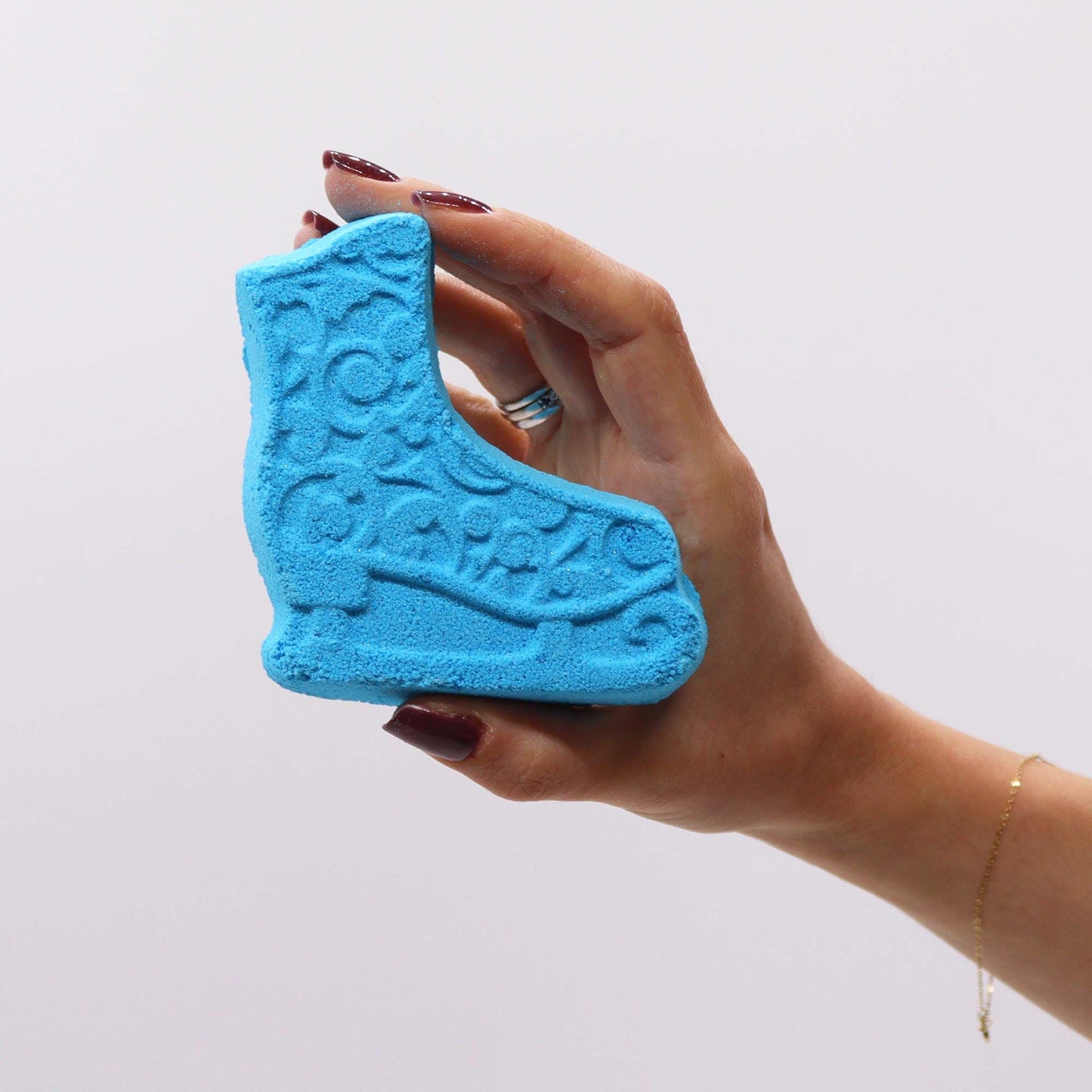 A close-up of the blue ice skate bath bomb from the Christmas Fun Bath Bomb Gift Pack, highlighting its intricate design. This unique bath bomb emits a pleasant Frosted Sugar Plum scent, making it a charming addition to any festive holiday gift.