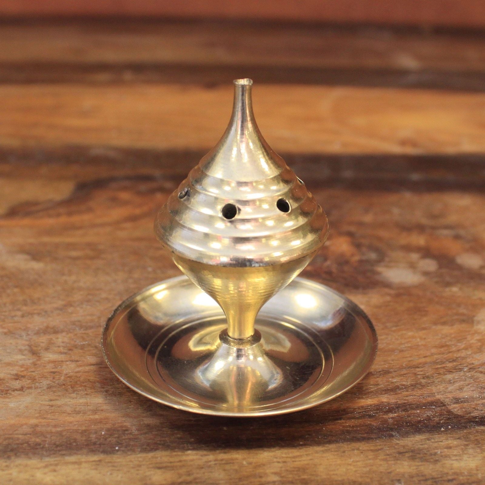 Small Brass Incense Burner - Elegant Design for Meditation resting on a wooden surface, showcasing its polished brass finish. Ideal for creating a calming atmosphere, this incense burner is the perfect Christmas gift for home fragrance enthusiasts.