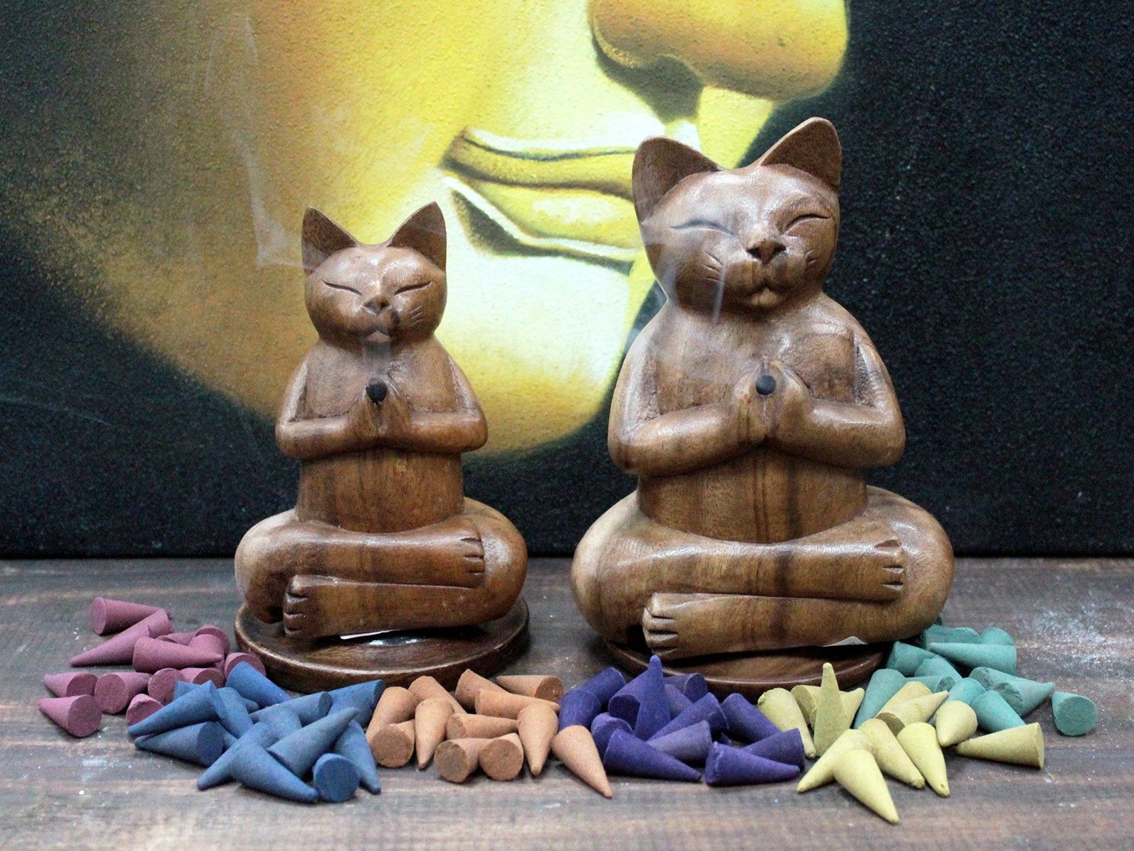 Two Hand-Carved Yoga Cat Incense Burners displayed with various incense cones around them. Ideal for cat lovers, this charming product serves as a great Christmas gift and enhances home fragrance.