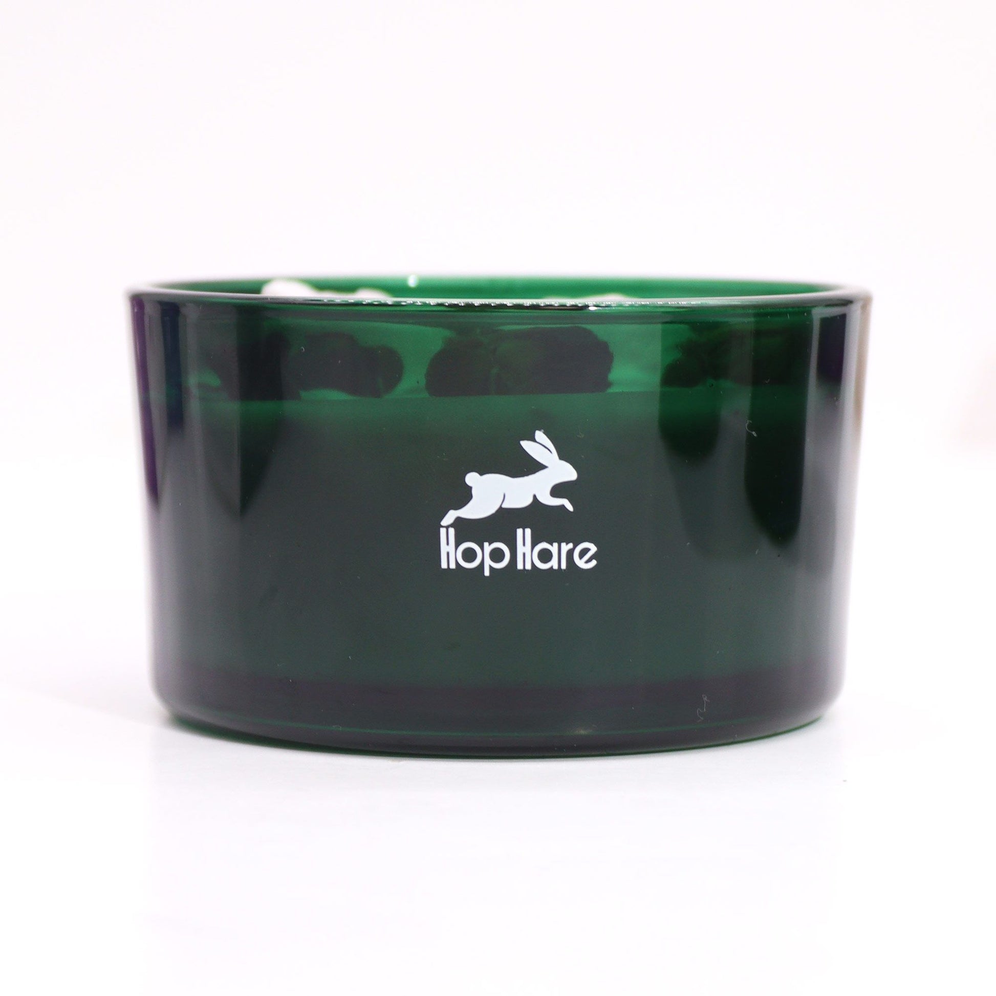 Close-up view of a Hare Crystal Flower Candle - Knight of Swords in an elegant green glass container, highlighting its artistry and charm. A delightful home scent option and perfect as a Christmas Gift Home Fragrance.