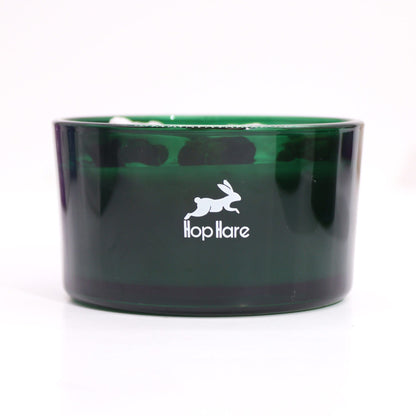 Close-up view of a Hare Crystal Flower Candle - Knight of Swords in an elegant green glass container, highlighting its artistry and charm. A delightful home scent option and perfect as a Christmas Gift Home Fragrance.