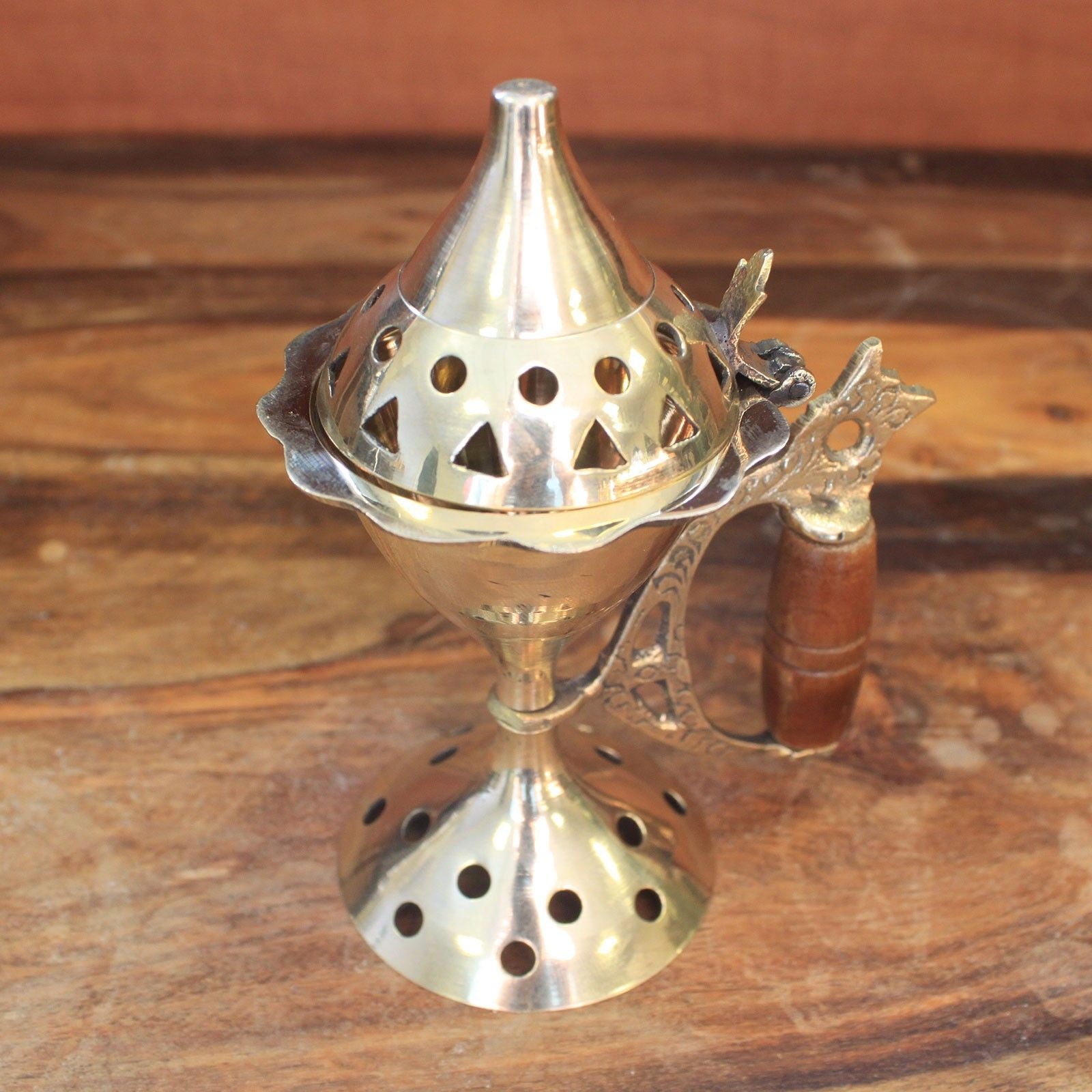 Close-up view of the Elegant Brass Cone Incense Burner with Carved Handle, featuring a unique vented lid and polished brass finish, making it a charming decor piece and perfect for Christmas gift home fragrance.
