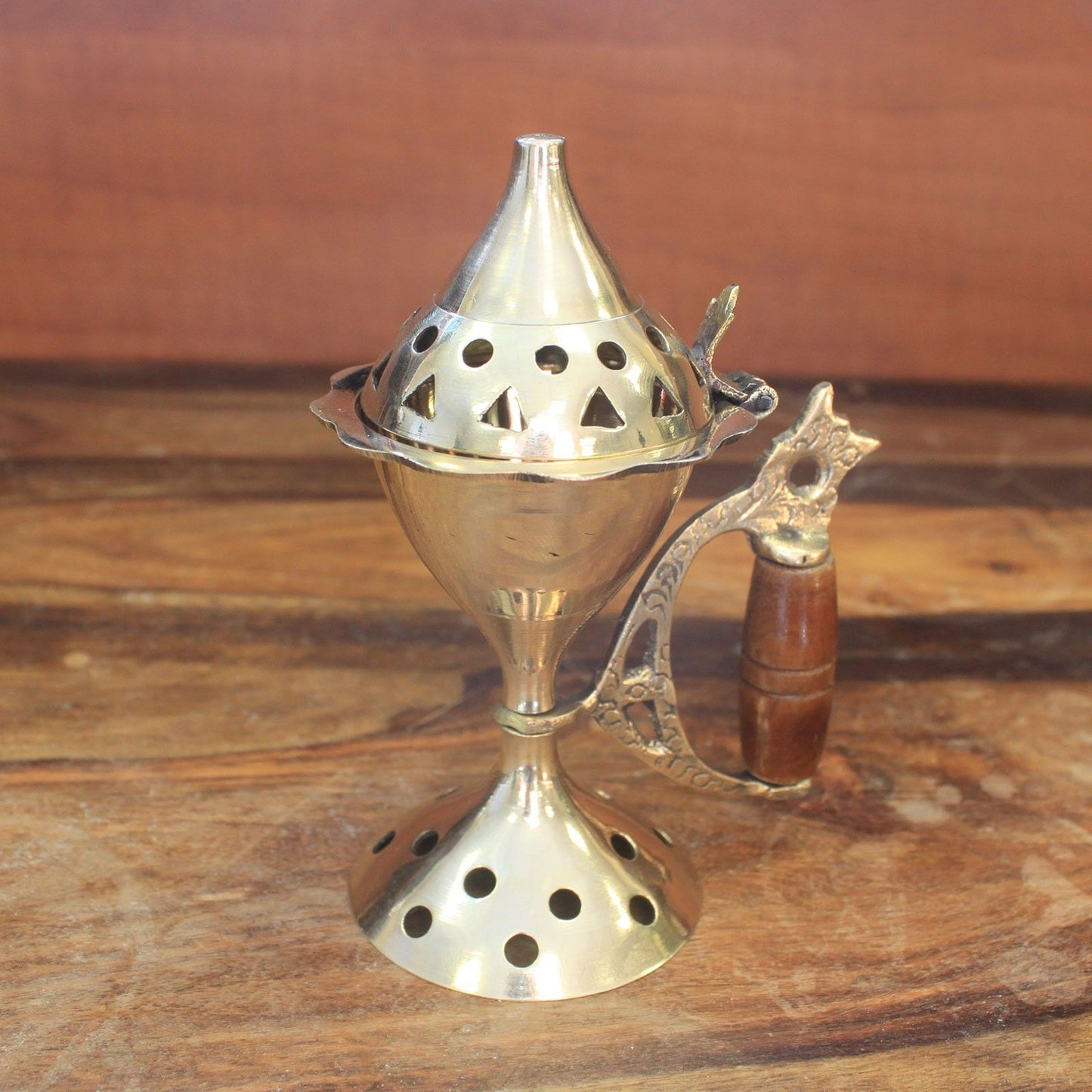 Elegant Brass Cone Incense Burner with Carved Handle displayed on a wooden surface, highlighting its craftsmanship and functionality, an excellent choice for a Christmas gift and home fragrance.