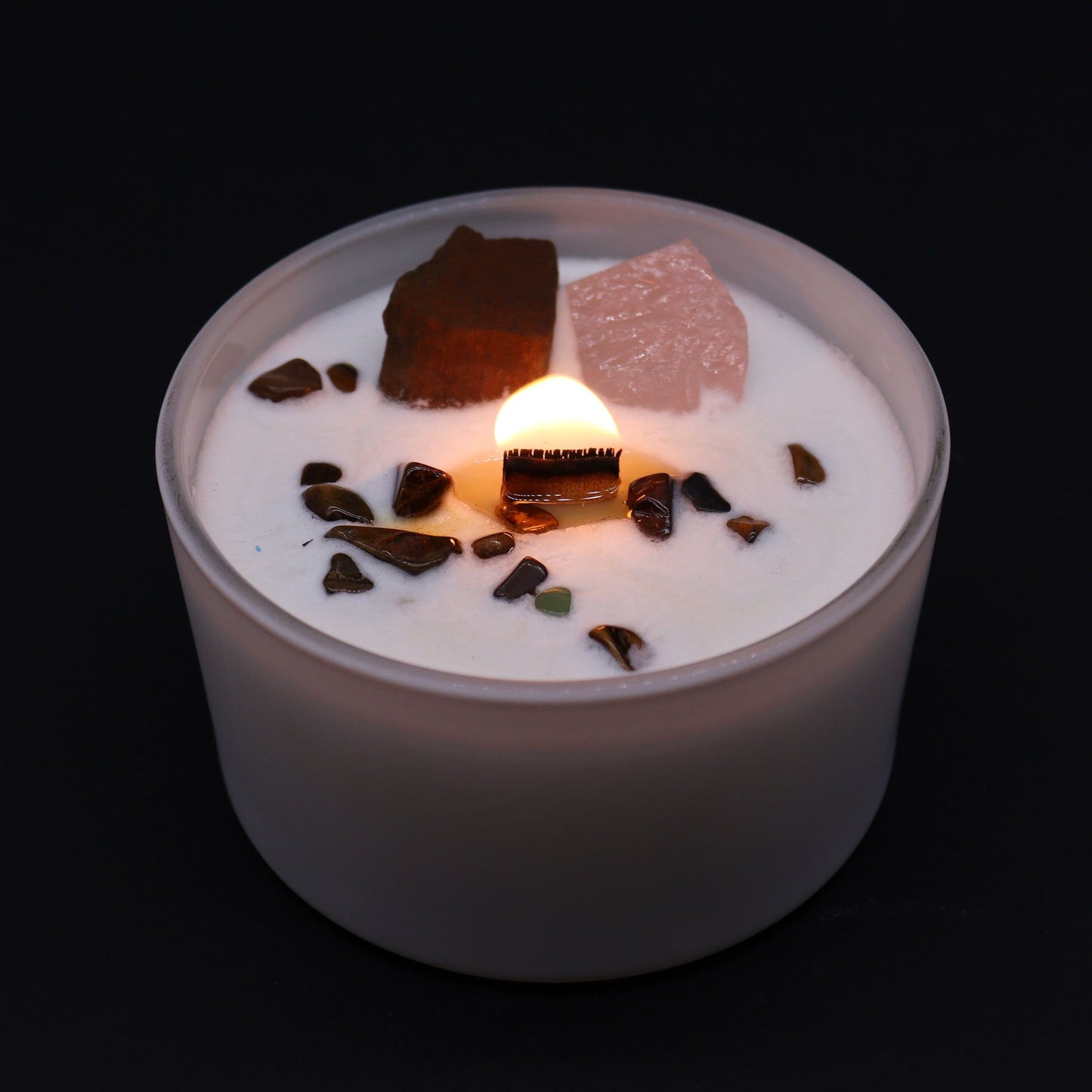 Sacral Chakra Candle with Tiger Eye & Rose Quartz – Ignite Creativity. The candle lit, showcasing the warm glow alongside the infused crystals, creating a delightful home fragrance experience for Christmas.