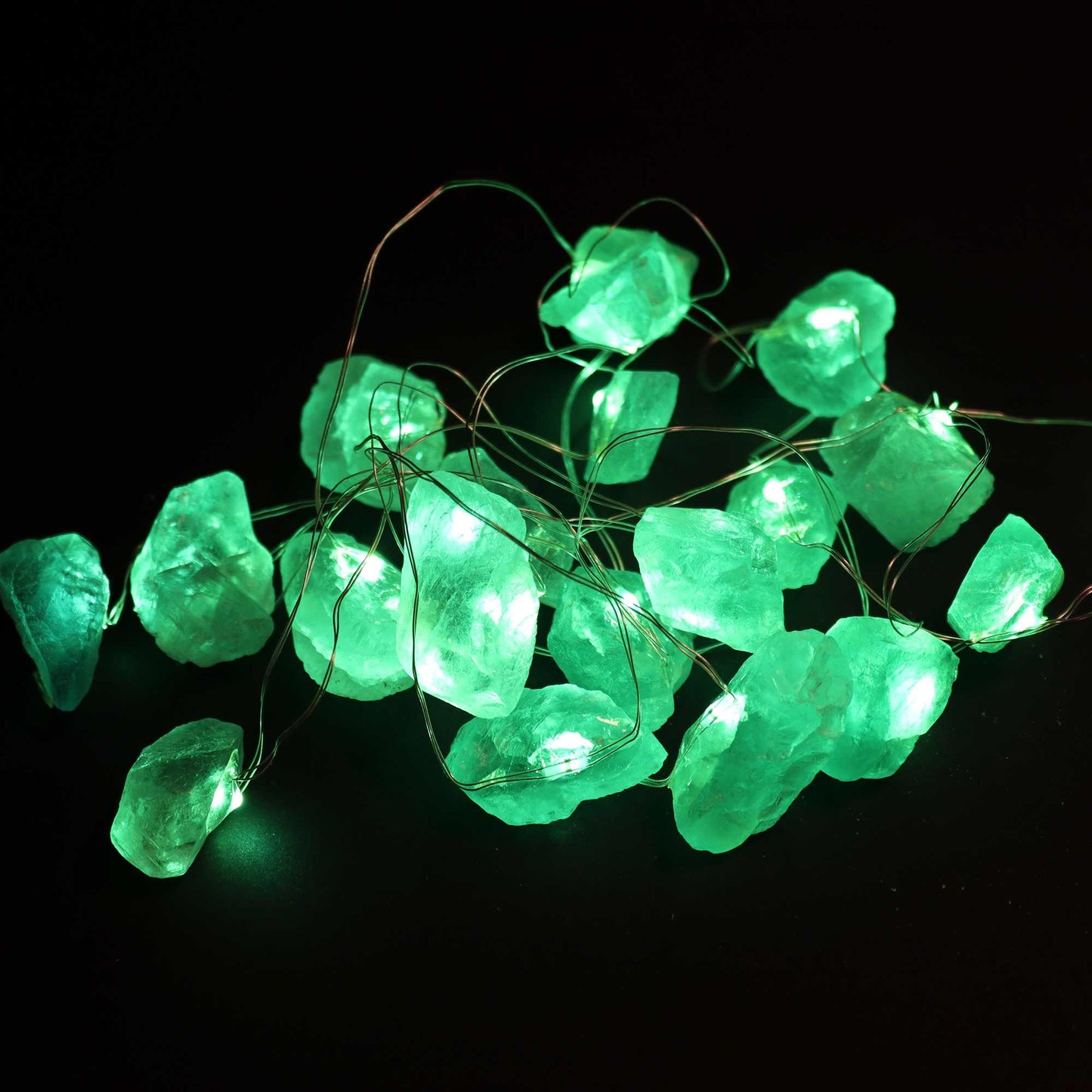 Illuminate your space with Crystal Jade Gemstone Enchantment Lights, showcasing glowing green rocks on a dark background. These lights create a magical ambiance for any occasion. {{scent}} {{product_type}} – Christmas Gift Home Fragrance.