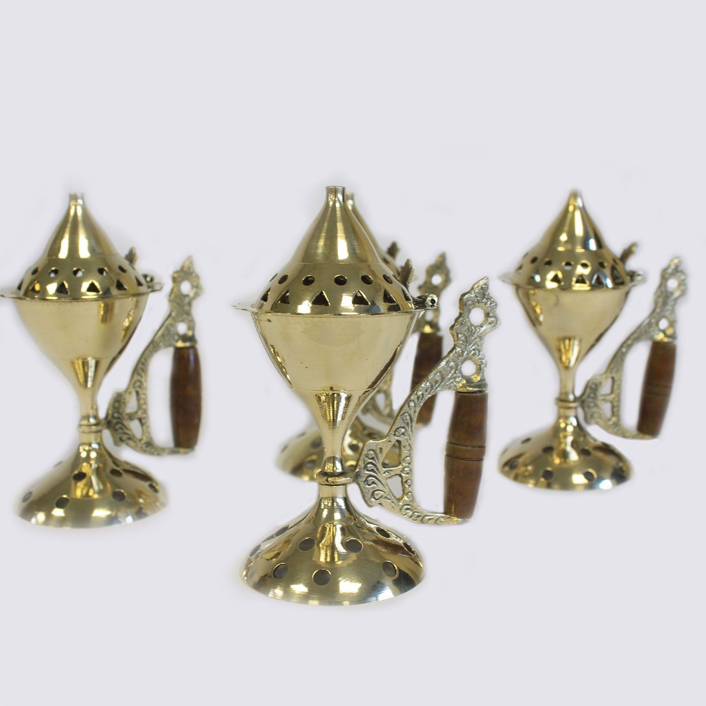 Multiple Elegant Brass Cone Incense Burners With Wooden Handles arranged together, perfect for rituals and creating a soothing atmosphere. These stylish burners are perfect as Christmas gifts and enhance any home fragrance experience.