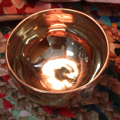 Close-up view of an Extra Large Handmade Singing Bowl - 21cm, 1200g, Ideal Gift, reflecting warm light and showcasing its unique handmade design. Ideal for meditation and relaxation. {{scent}} {{product_type}} – Christmas Gift Home Fragrance.
