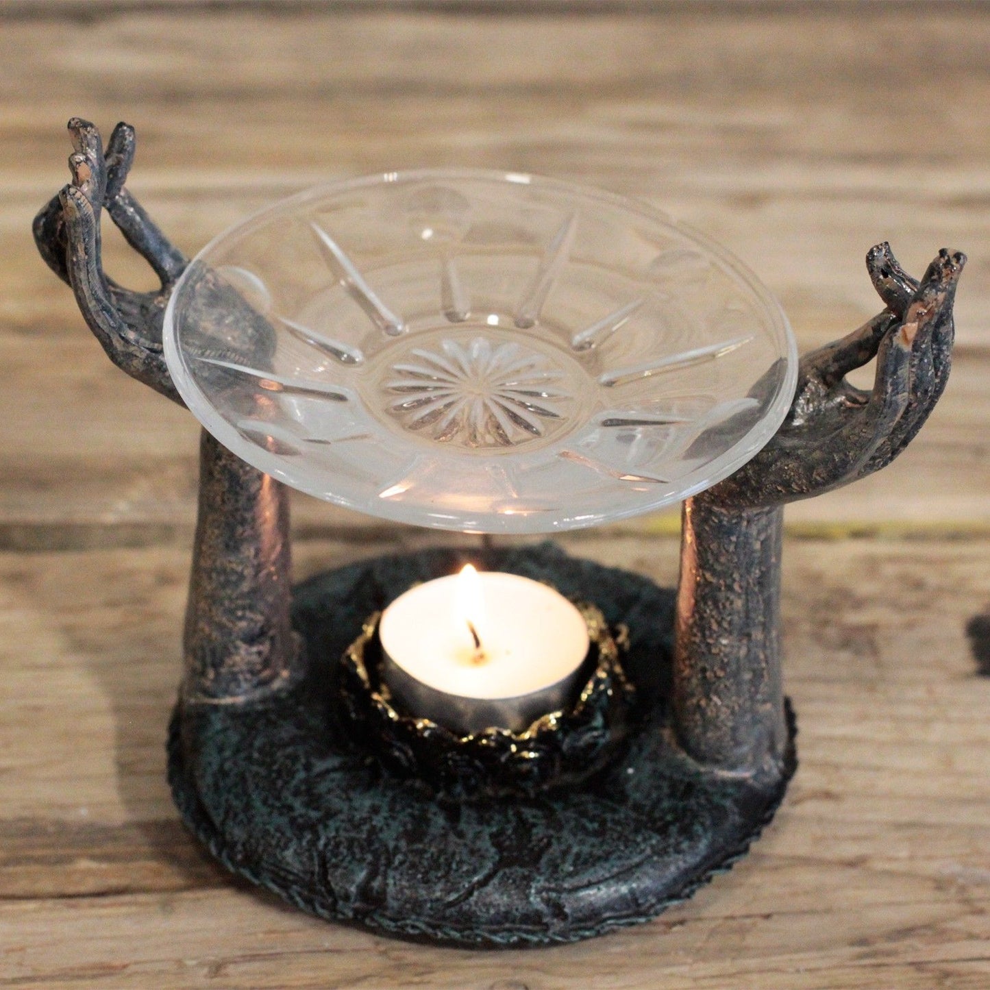 Antique Buddha Om Hands Oil Burner – Zen Home Decor illustrating a striking oil burner with open hands supporting a glass dish above a lit candle, contributing to a peaceful atmosphere. Perfect for a Christmas Gift Home Fragrance.