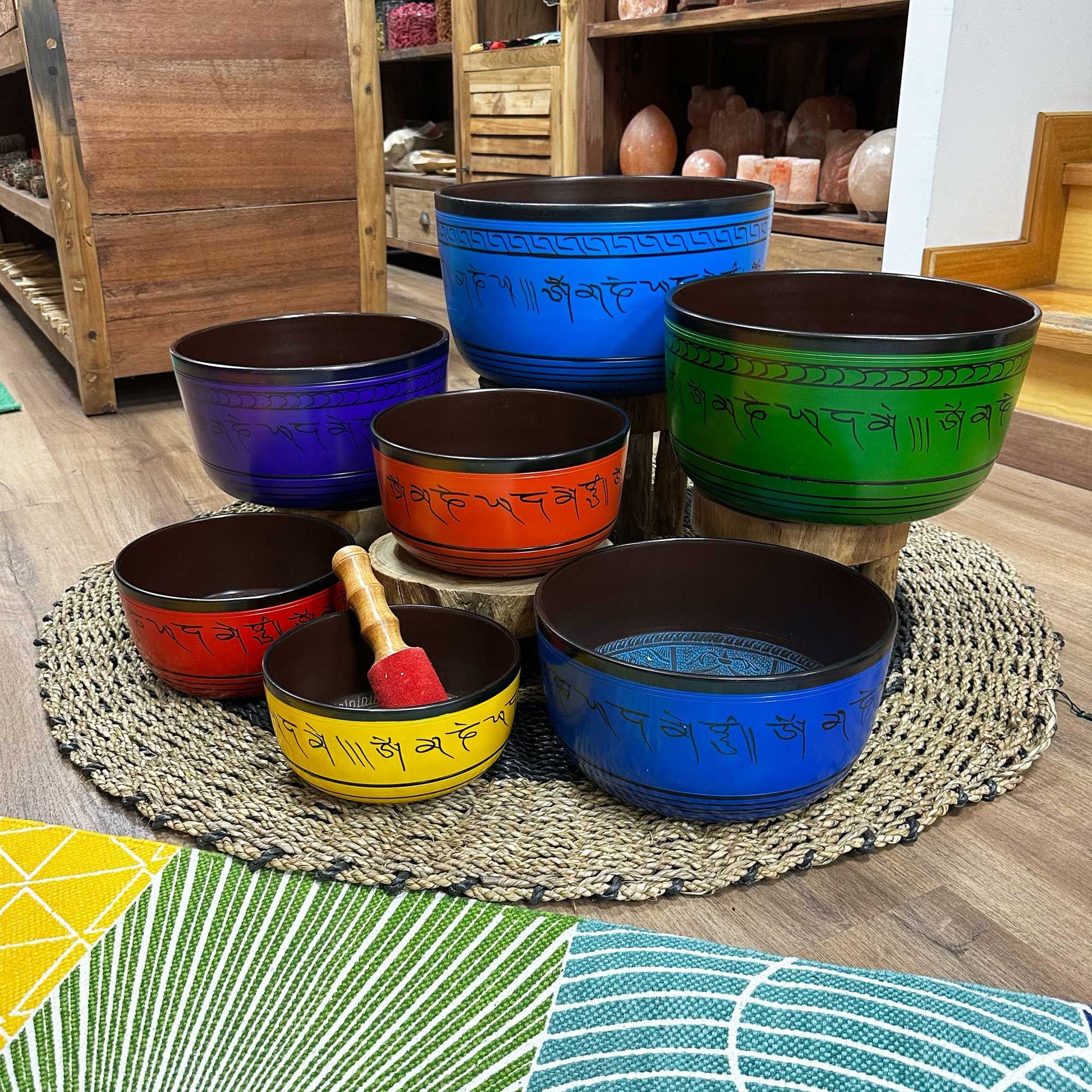 Large 7 Chakra Singing Bowls Set displayed on a rustic surface, showcasing the vibrant collection of seven bowls in various colours, perfect for creating a serene atmosphere at home. A thoughtful Christmas gift for sound healing.