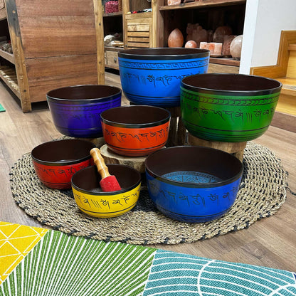 Large 7 Chakra Singing Bowls Set displayed on a rustic surface, showcasing the vibrant collection of seven bowls in various colours, perfect for creating a serene atmosphere at home. A thoughtful Christmas gift for sound healing.