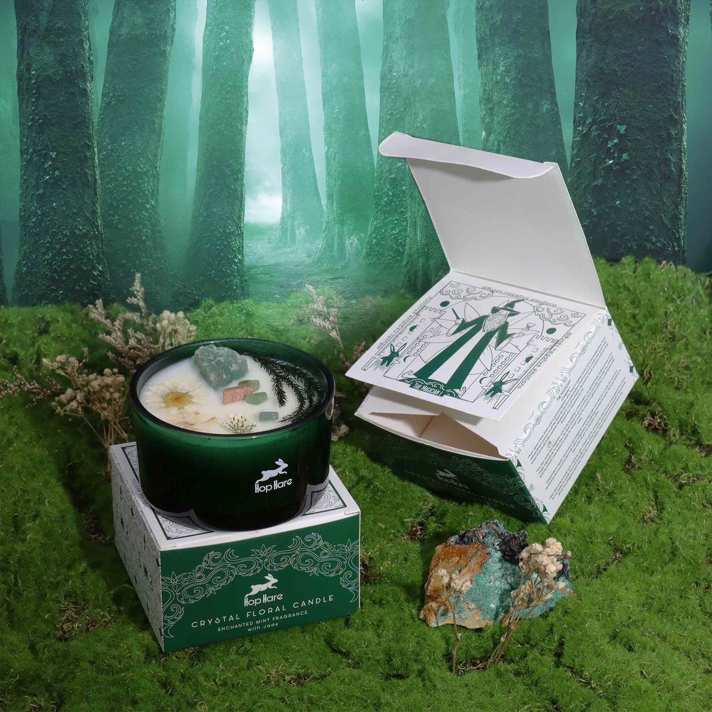 Hop Hare Crystal Flower Candle - Enchanted Mint with Jade Gemstone placed in a magical forest setting, accompanied by its elegant box. This mint scented candle offers a captivating experience, making it a perfect Christmas gift for home fragrance enthusiasts.
