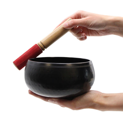 Large Black Singing Bowl - 18Cm for Meditation and Relaxation, shown in use with a hand gently striking it with a mallet, ideal for deep relaxation sessions. {{scent}} {{product_type}} – Christmas Gift Home Fragrance.