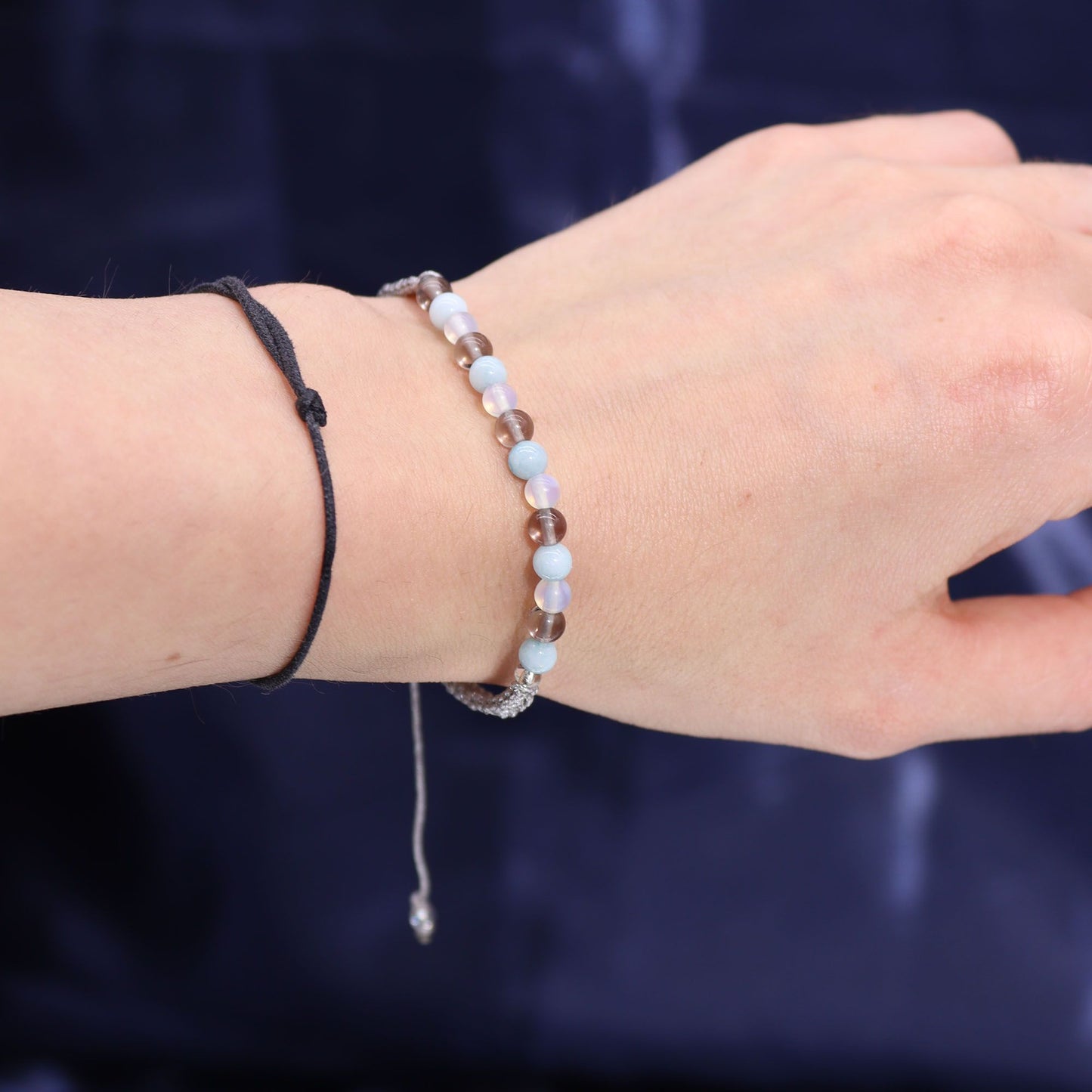 Close-up of a hand wearing the Cancer gemstone bracelet, highlighting aquamarine and smoky quartz, ideal for a thoughtful Christmas Gift Home Fragrance with soothing scents.