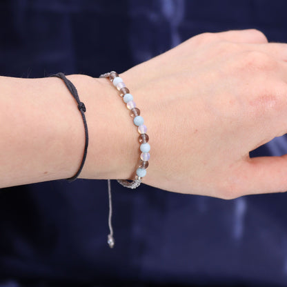 Close-up of a hand wearing the Cancer gemstone bracelet, highlighting aquamarine and smoky quartz, ideal for a thoughtful Christmas Gift Home Fragrance with soothing scents.
